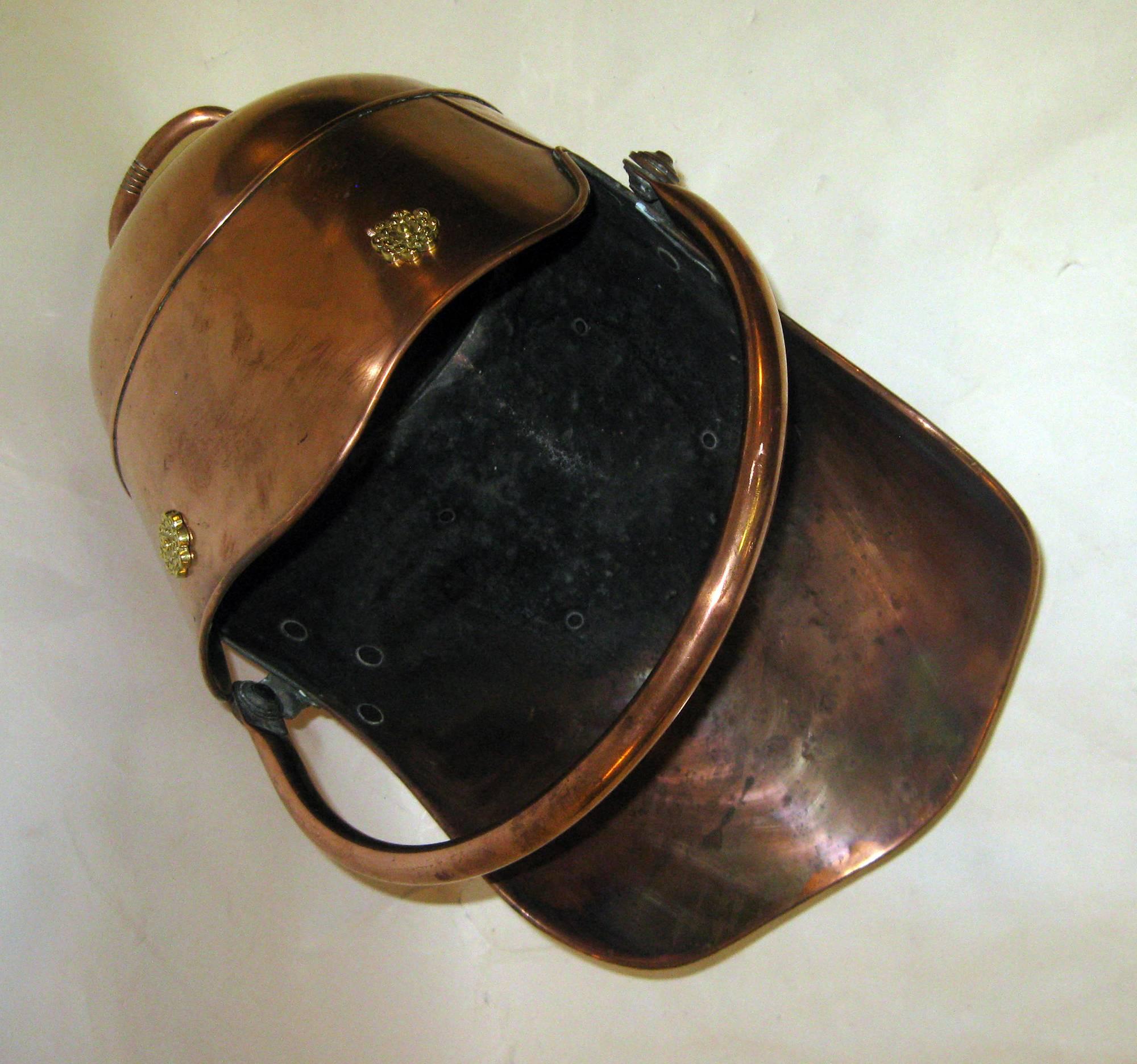 Scottish Helmet shaped coal scuttle/ hod with nice form, shape and size. Adjustable handle riveted to back with applied brass ornamentation at top. 
Measures: 16 inches tall when handle is up-14 inches when down.
See other measurements below.