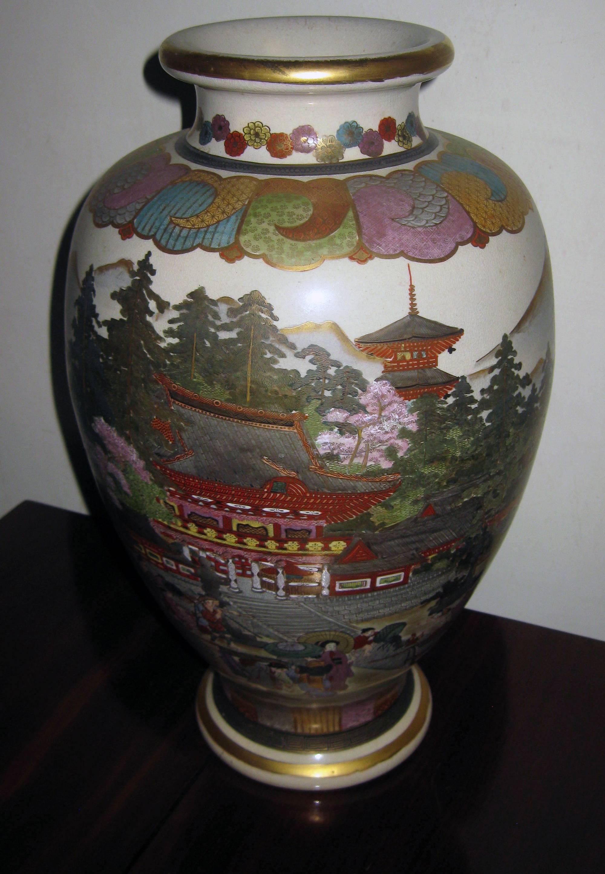 Pair of nice size vases with relief decoration of painted enamel and gilt with fine detail featuring landscape and figures. This high quality export Satsuma is easily recognized by the fact that its earthenware body does not ring when tapped and by