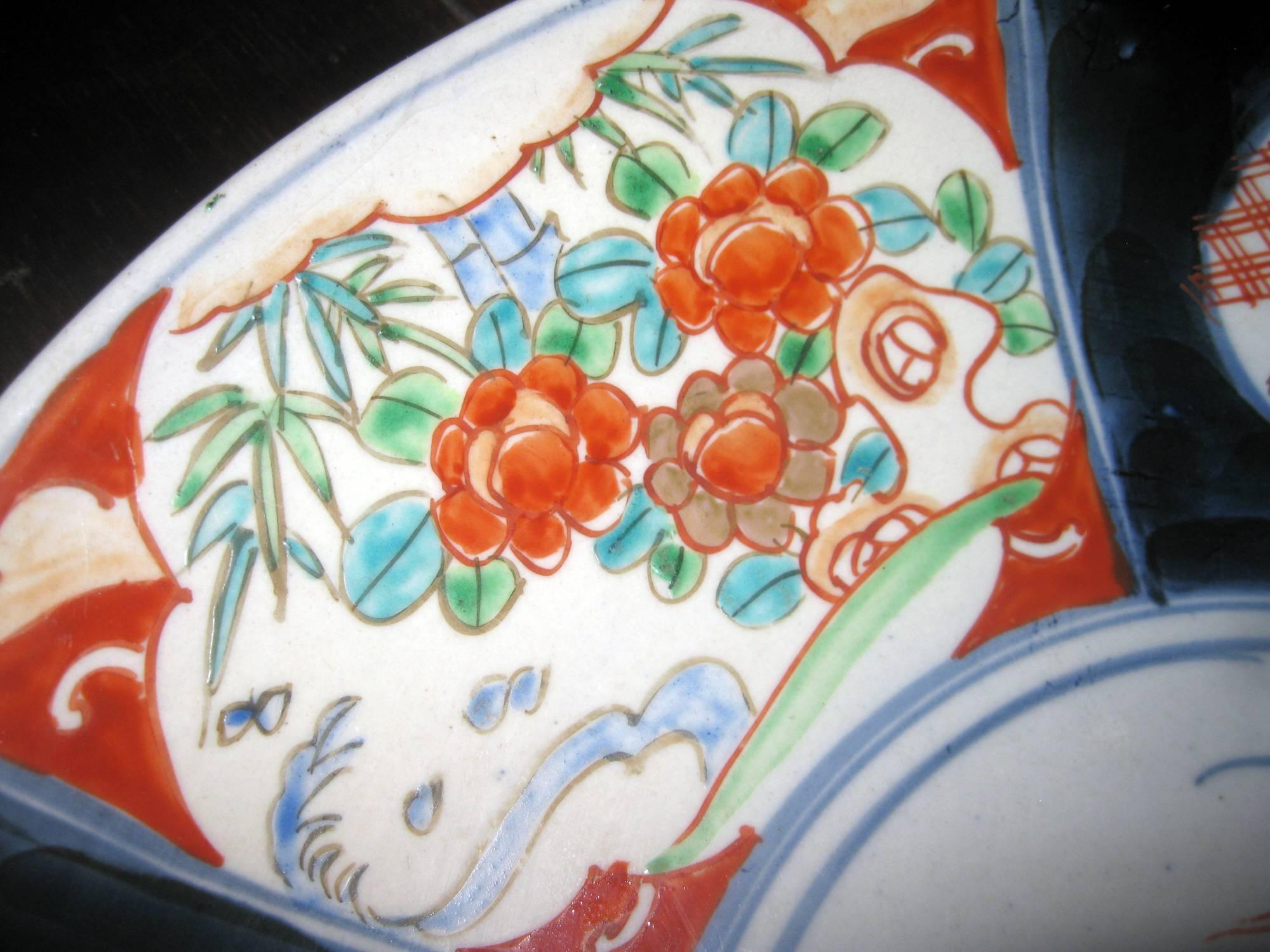Japanisches Ladegerät aus der Meiji-Dynastie in einer provinziellen Imari-Palette. Zu den Merkmalen gehören sechs florale Tafeln in einer Palette von fünf Farben und eine etwas schlichte Dekoration im mittleren Medaillon. Auffällige kobaltfarbene
