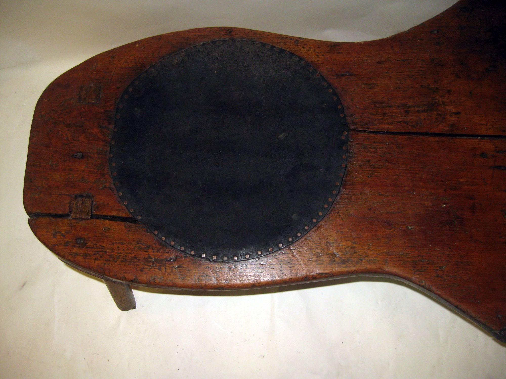 A great addition to any Folk Art or Americana collection, this cobbler’s bench is in "as found" condition and retains its original worn surface. It is constructed of maple with oak doweled legs and a seat of rawhide, which has probably