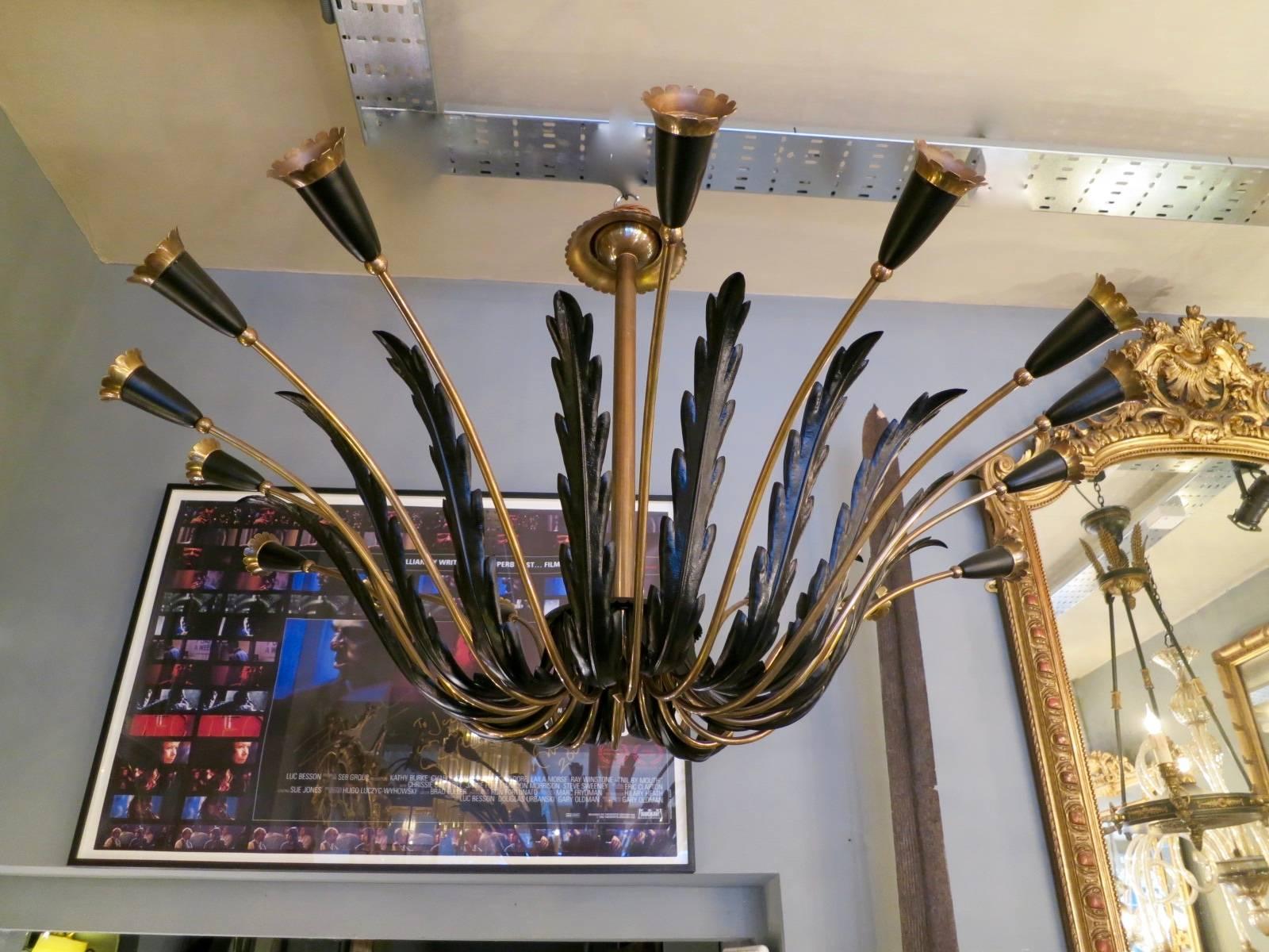 A large Sputnik style chandelier from the Mid-Century period, in black and patinated brass with 16 arms. Expertly restored and in fantastic condition. In the manner of early Stilnovo and Arredoluce lights.