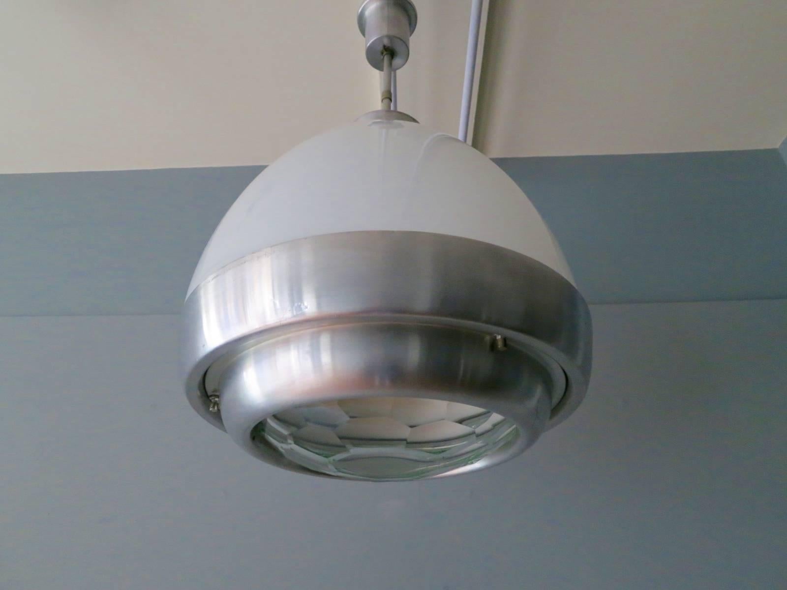 Un grande pendente in vetro bianco e alluminio con diffusore in vetro sfaccettato. Di Pia Guidetti Crippa per Lumi.