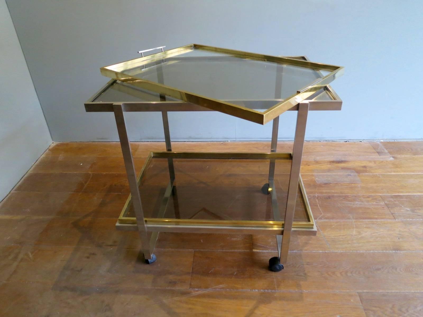 A brass and chrome two-tiered bar cart with removable top tray, also with hidden handles that slide up for use. Continental.