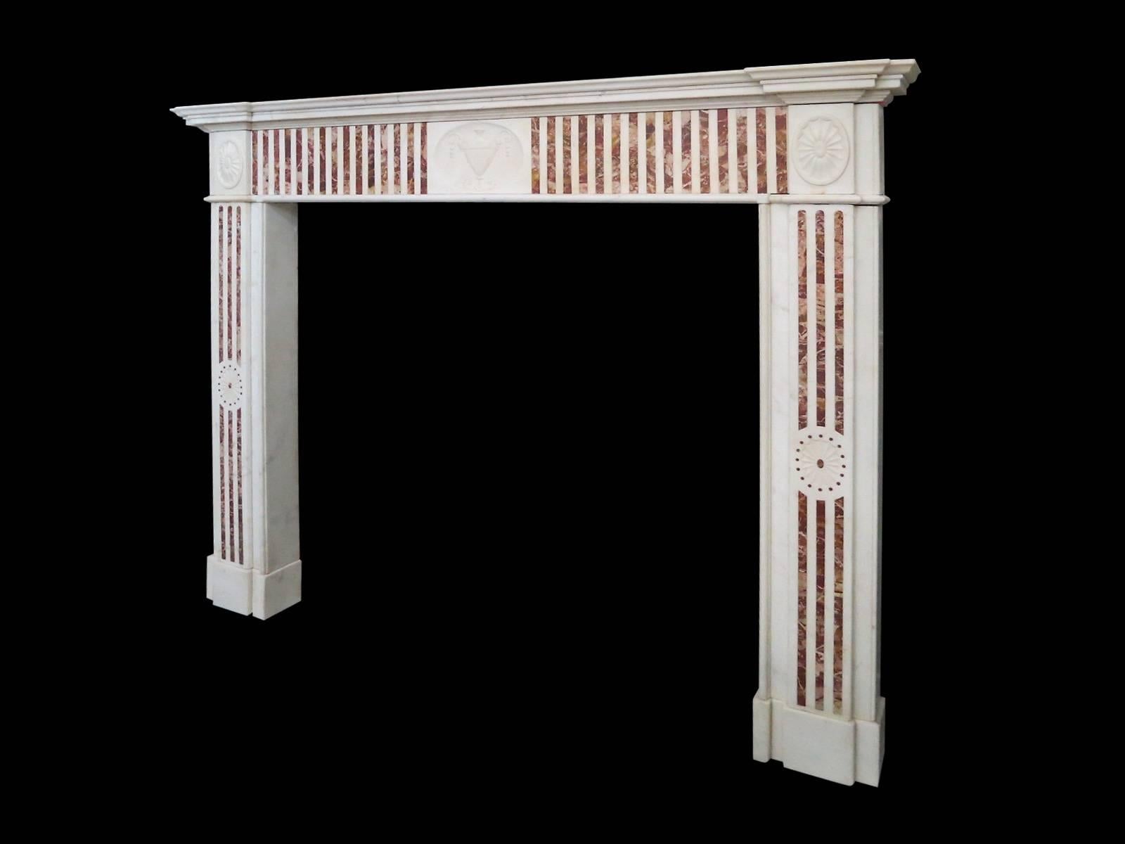 An Irish, George III period surround in Statuary white and Sicilian Jasper Marbles. 
The pilaster fluted jambs with Jasper inlay and carved elliptical rosettes. The centre tablet of carved classical urn flanked either side by conforming Jasper