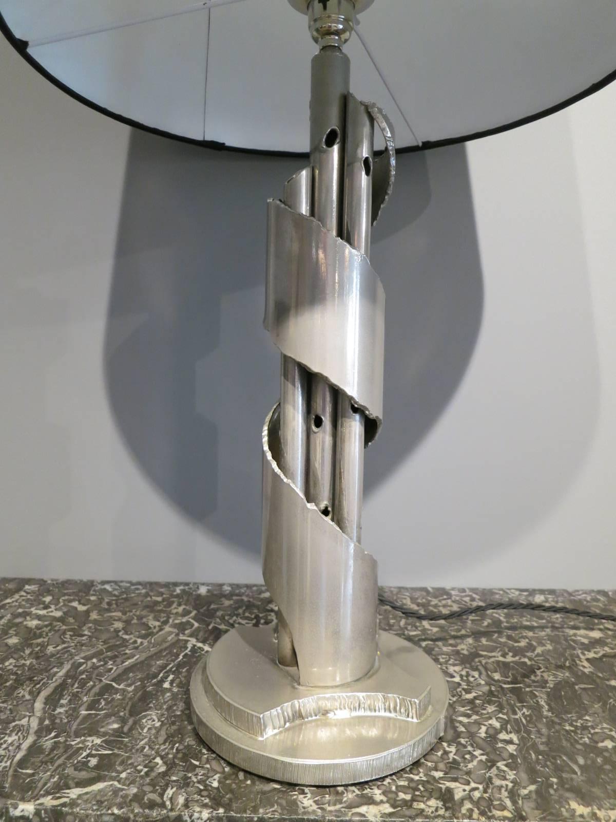 A Brutalist table lamp in steel with handmade silk shade in black.