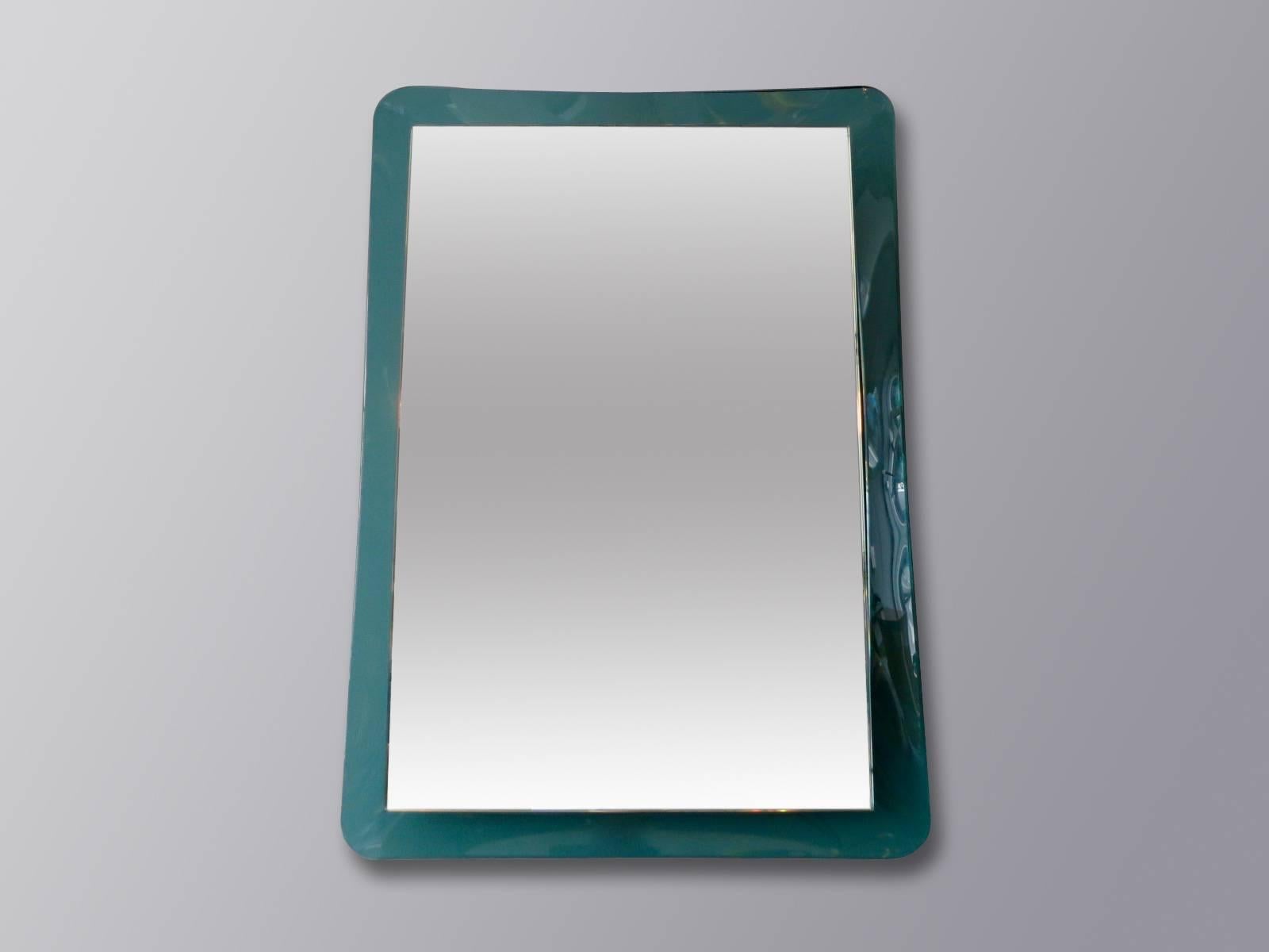 A rectangle mirror sitting in a thick aquamarine concave piece of glass. With chrome fittings. Very good quality and original mirror.