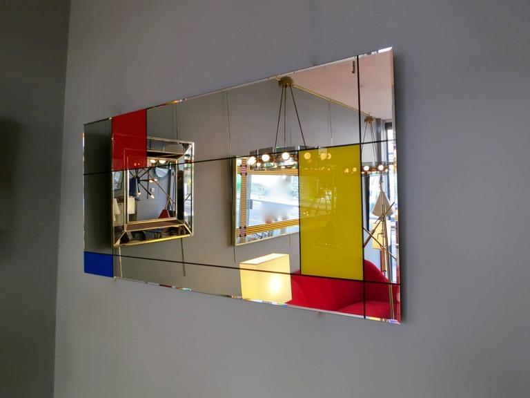 A graphically designed rectangle mirror by Italian manufacturer Rimadesio. The design of the mirror is very much in the manner of paintings by Piet Mondrian, with black lines forming square and rectangular blocks, in the primary colors red, blue and