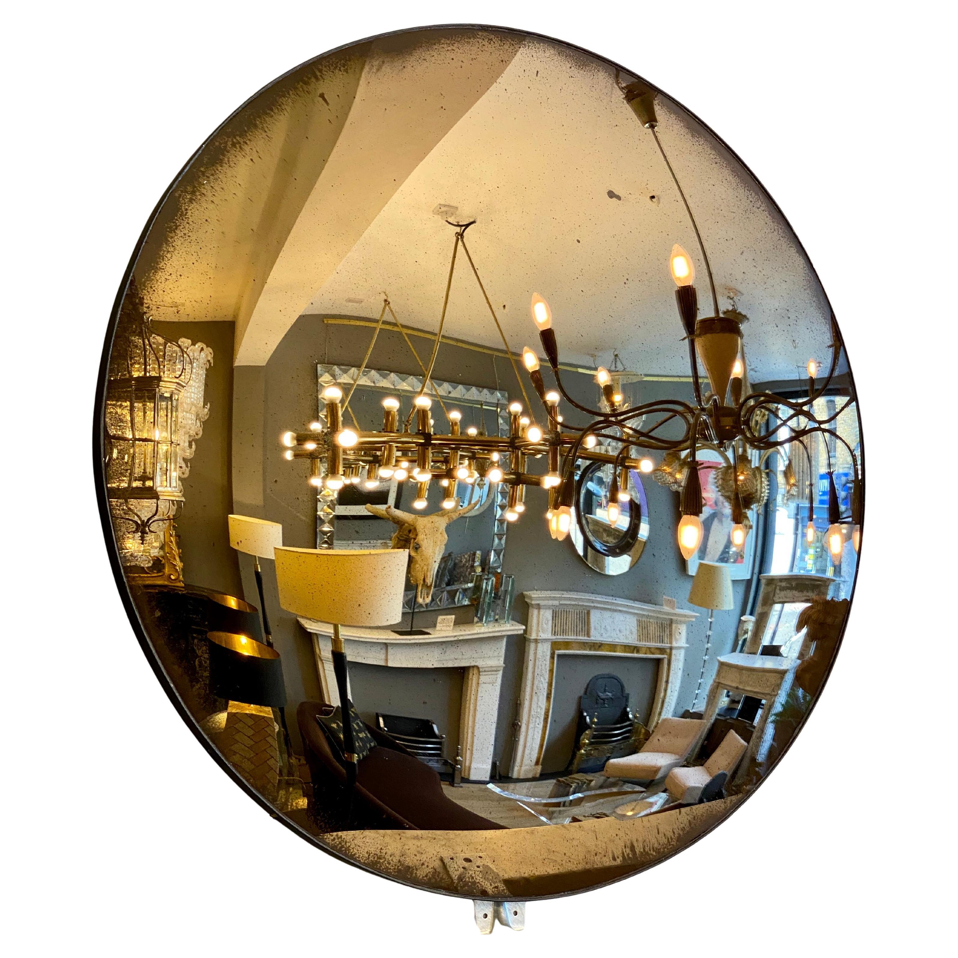 A contemporary convex bronze mirror, with distressed finish within a burnished steel banded frame. 

Handmade in the UK.