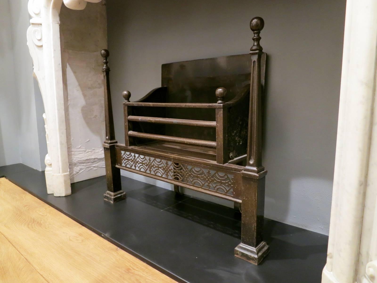 An attractive bronzed steel, Georgian style 19th century fire grate. The tall ball caped finials supported by rectangular pedestals, flanking intricately pierced fret work. The front bars again with ball finals and plain squared fire back, 19th