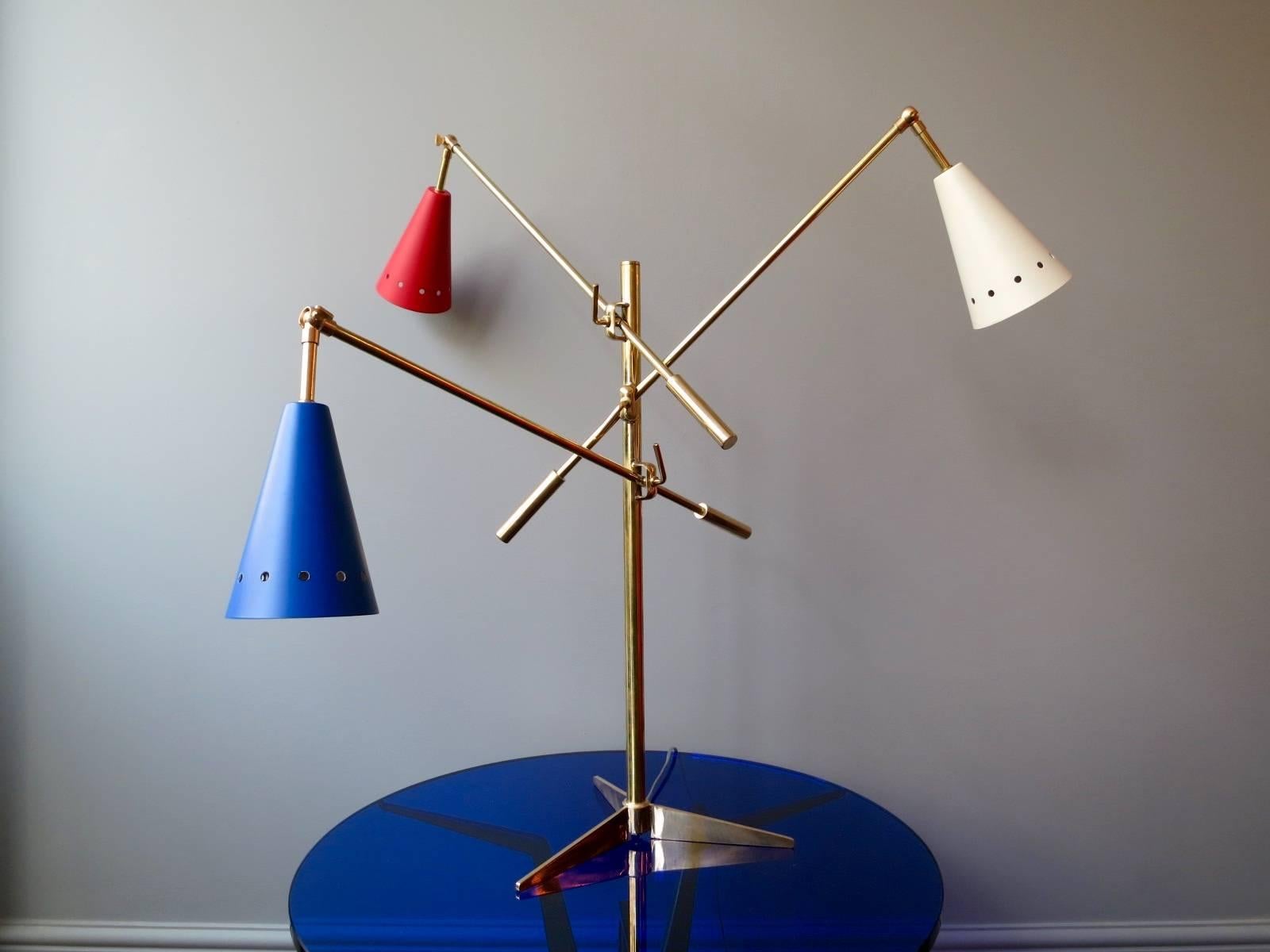 A Triennale style table lamp in brass with red, white and blue shades. A contemporary piece very well made. 

Measures: Height 80cm x width 86cm.