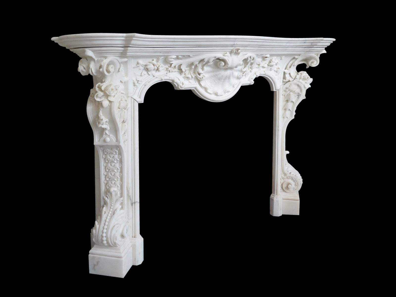 An extraordinary and rare 18th century fireplace in the Rococo manner. Exquisitely carved in high and low relief. The florally carved jambs supported on square foot blocks with deeply scrolled and beaded acanthus leaf, with foliage carving within