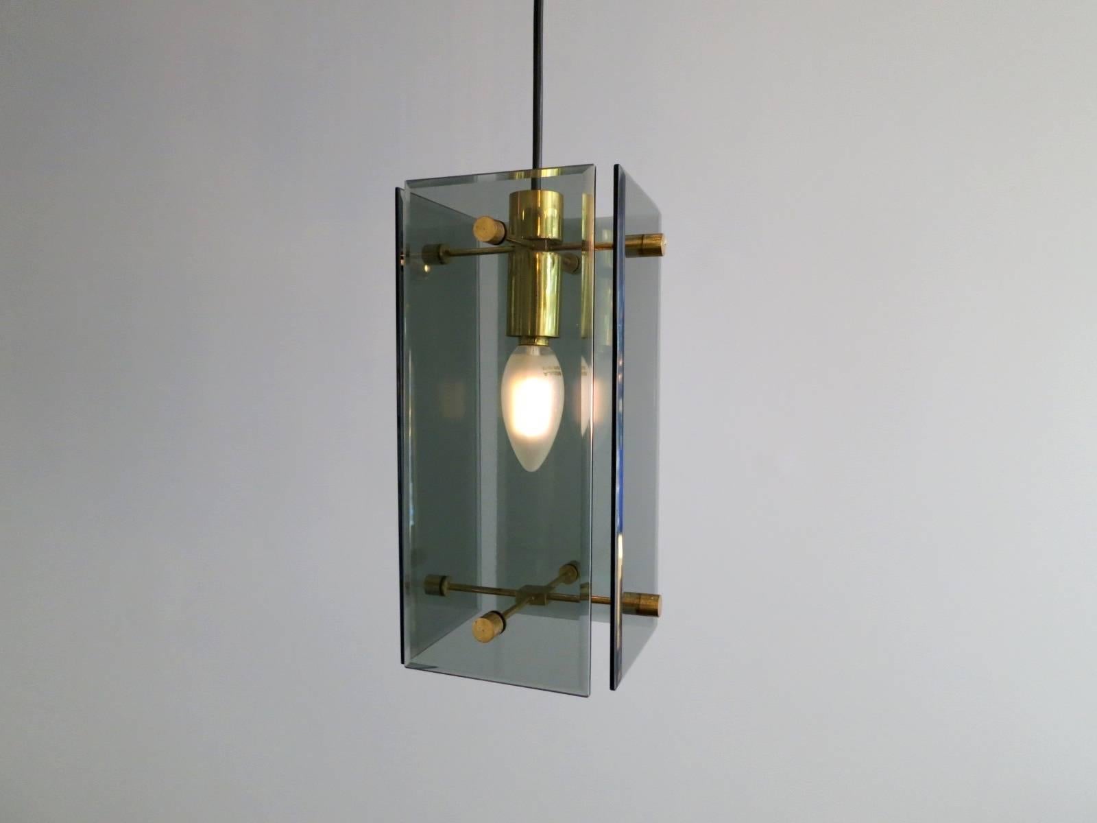 A Mid-Century ceiling light, in the manner of Fontana Arte. The bevelled glass diffusers held in place with brass supports, suspended from a circular black steel dish. Height can be adjusted,

circa 1950-1960s.

Measures: 100 cm drop x 30 cm