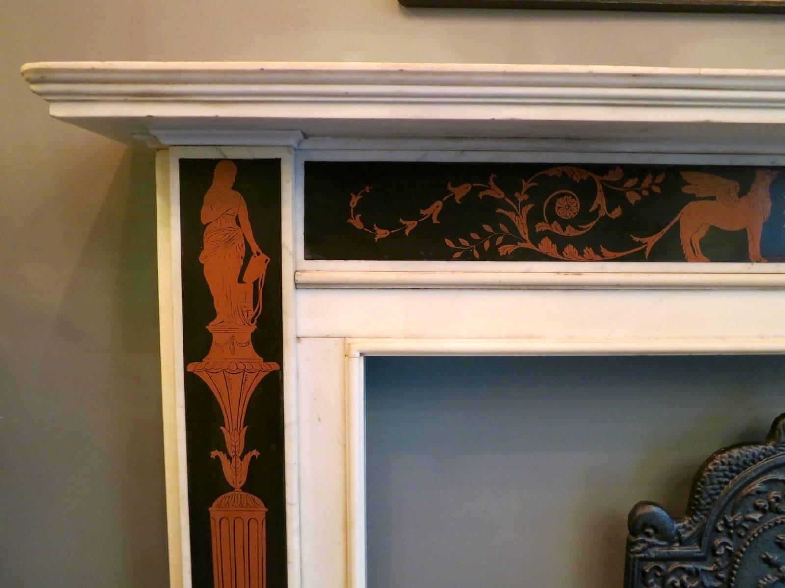 An Irish 19th century highly decorative and very well executed fireplace in Italian Statuary white marble with red and black Etruscan style  Scagliola inlaid jamb panels and frieze. The jambs depicting classical figures atop fluted tapering
