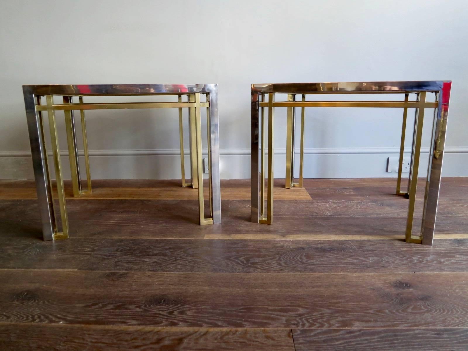 A pair of side or end tables in brass and chrome with tinted glass tops and geometric design, by Romeo Rega. There is also a matching coffee table available from this range in a separate listing.