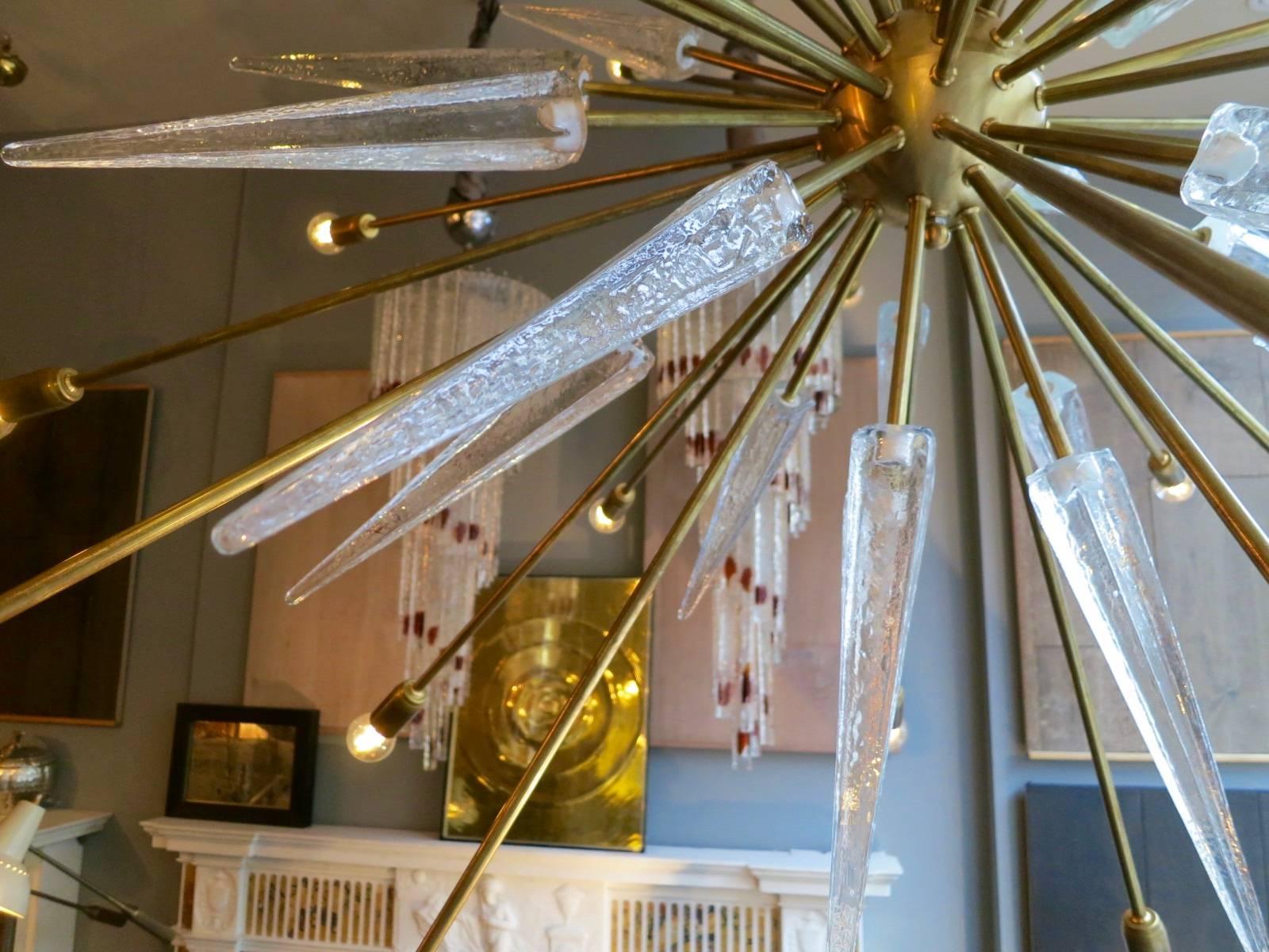 An oversized sputnik chandelier. In typical Mid-Century style with 30 bulb arms and thick glass spiked mounts. A good quality contemporary decorative piece.