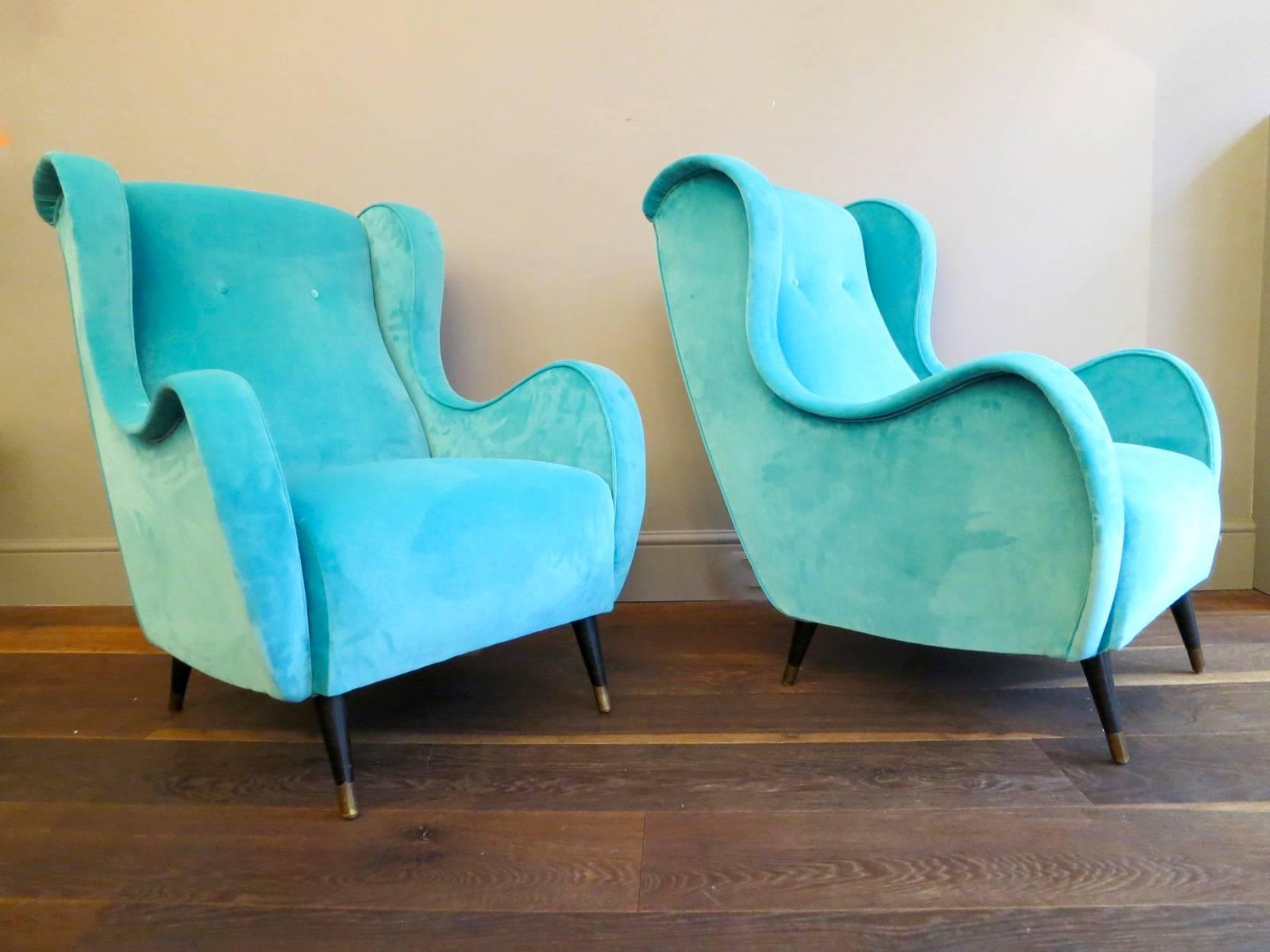 A large substantial pair of lounge chairs, re upholstered in Italian moleskin velvet on ebonised legs with brass sabots.