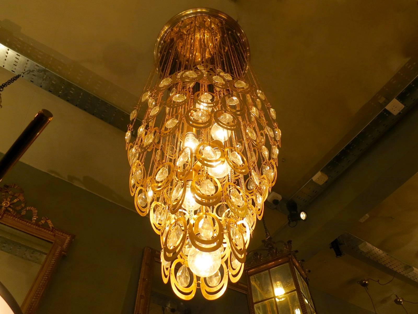 A large ceiling pendant in brass and glass, the ovoid shaped light suspended by brass chains with light fittings within. Attributed to Sciolari.