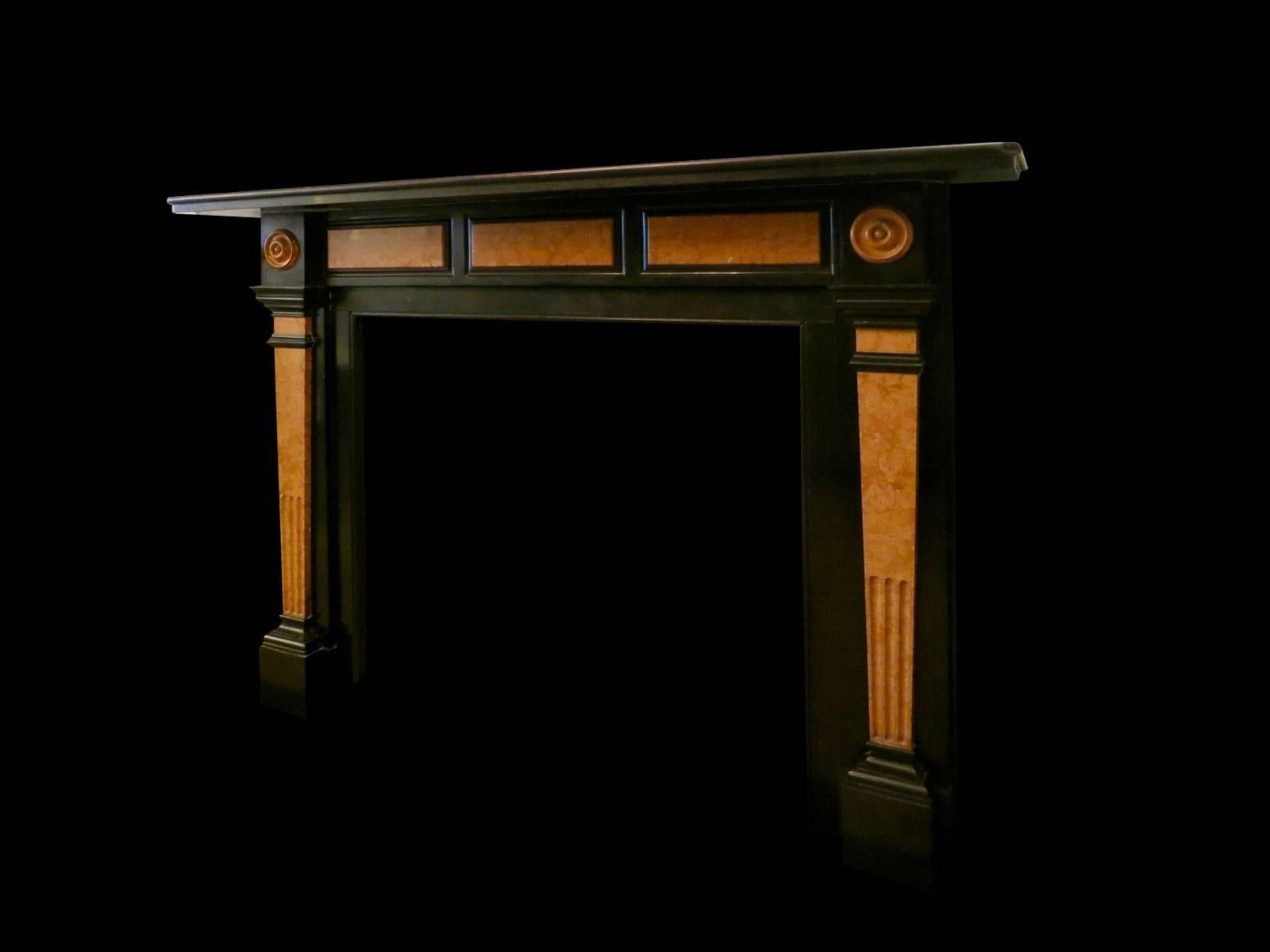 A large stylised and very well configured fireplace in Belgian black marble and Italian Verona marble. The jambs with tapering fluted panels in Verona, surmounted by corner blocks with roundels again in Verona. The frieze having three raised Verona
