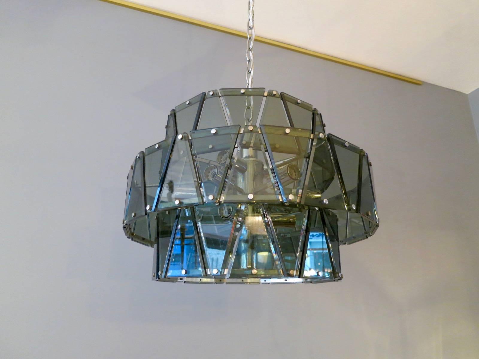 A three tiered chandelier attributed to Zero Quattro with green bevelled triangular pieces of glass on a chrome frame

circa 1960s

Measures: 50cm diameter x 30cm height (without chain) drop with chain 105cm.