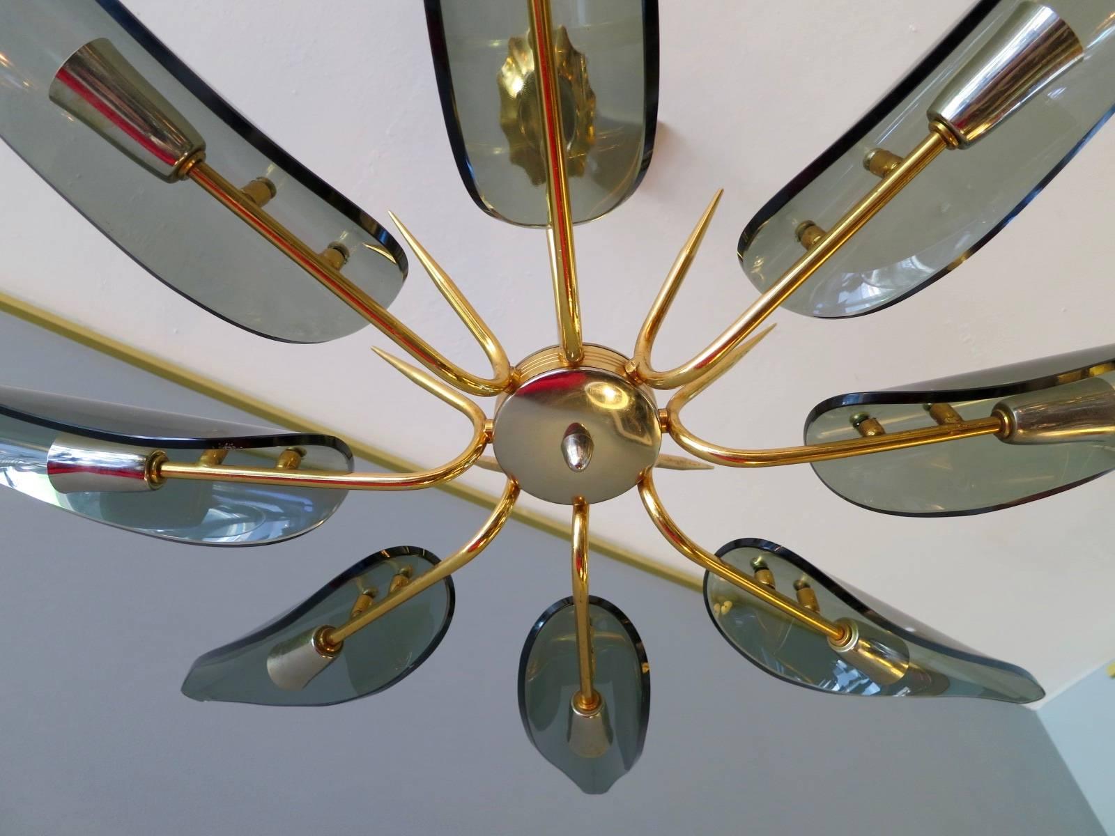 Un lustre de bonne qualité en nickel et laiton plaqué or avec de longs diffuseurs de lumière en verre courbé à la manière de Fontana Arte. Par Gino Paroldo 