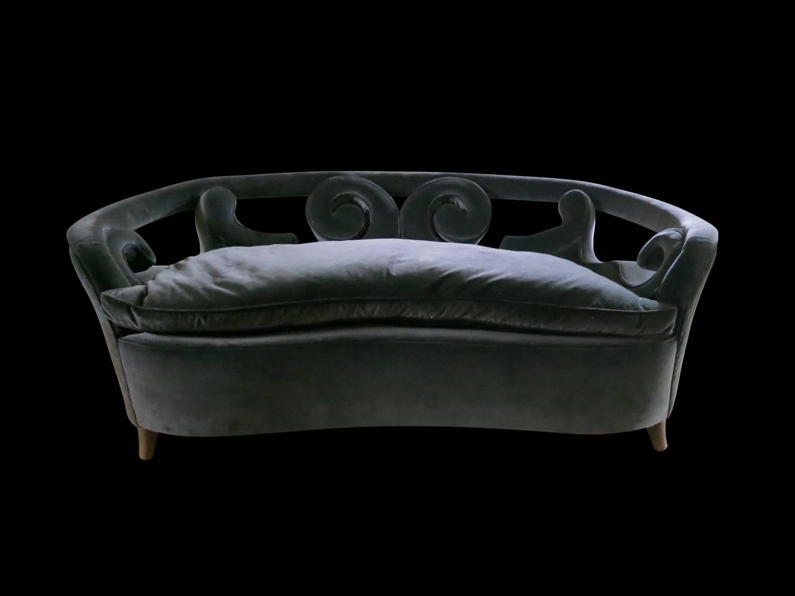 A gently curved two-seat sofa, covered in blue velvet with a decoratively upholstered back. Attributed to Italian designer Pier Luigi Colli. We can also offer the service of reupholstery if desired, with a fabric of your choice.