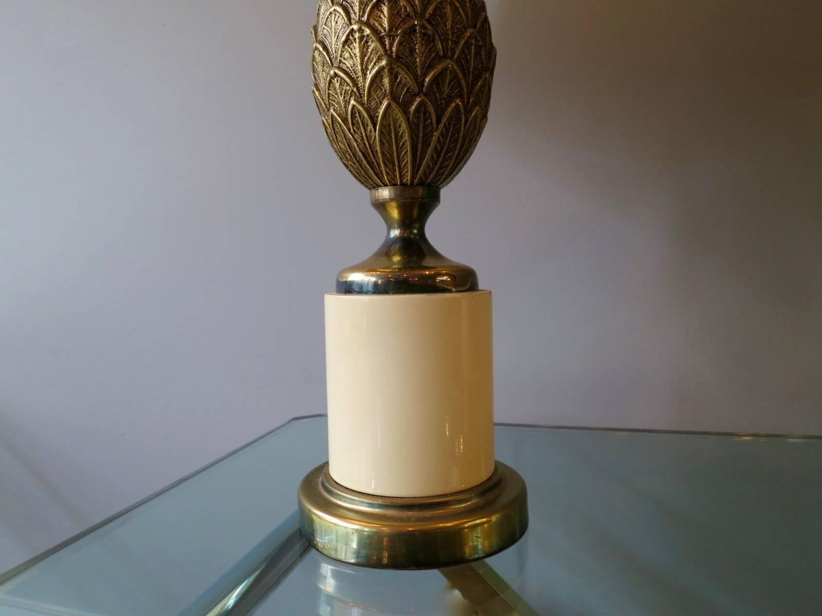 A small pair of pineapple lamps in brass with white lacquered plinth bases and linen shades. 

Measurements provided include shades.