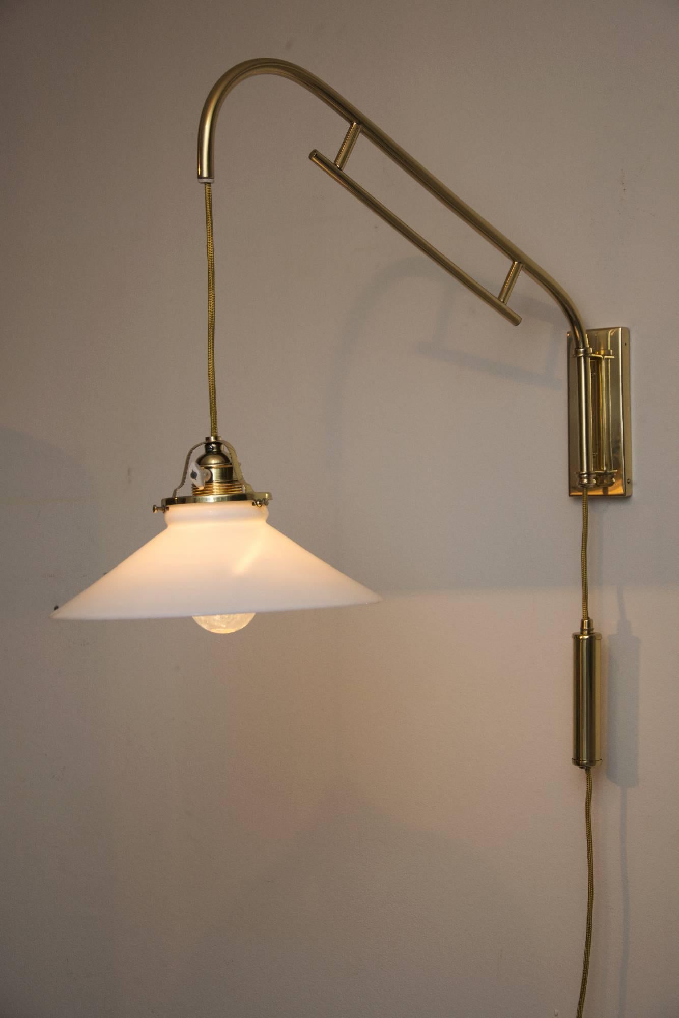 Adjustable wall lamp with opal glass shade
polished and stove enameled.