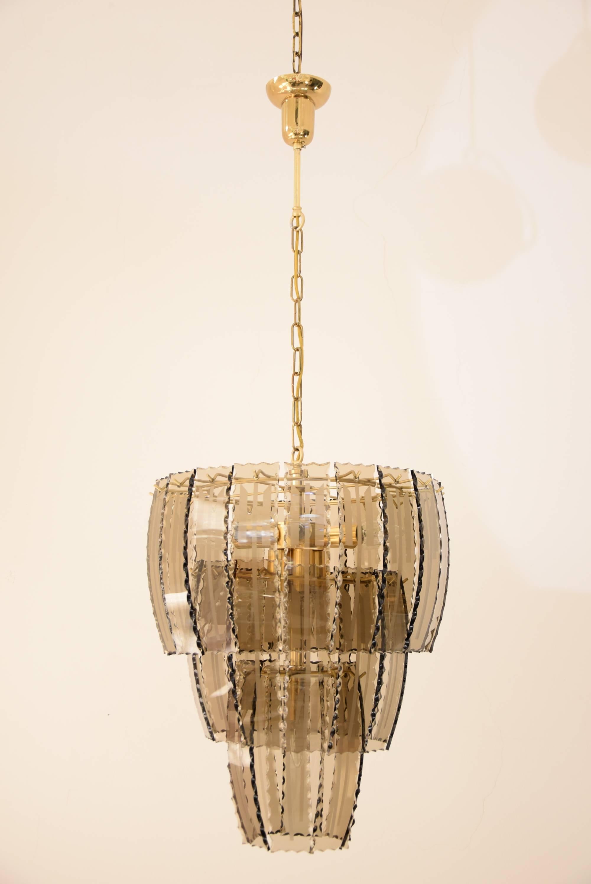 Beautiful big smoked glass serrated chandelier.
Midcentury eight-light chandelier features three tiers of curved, serrated smoked glass panels.
11 bulbs.
The high is adjustable for different rooms.