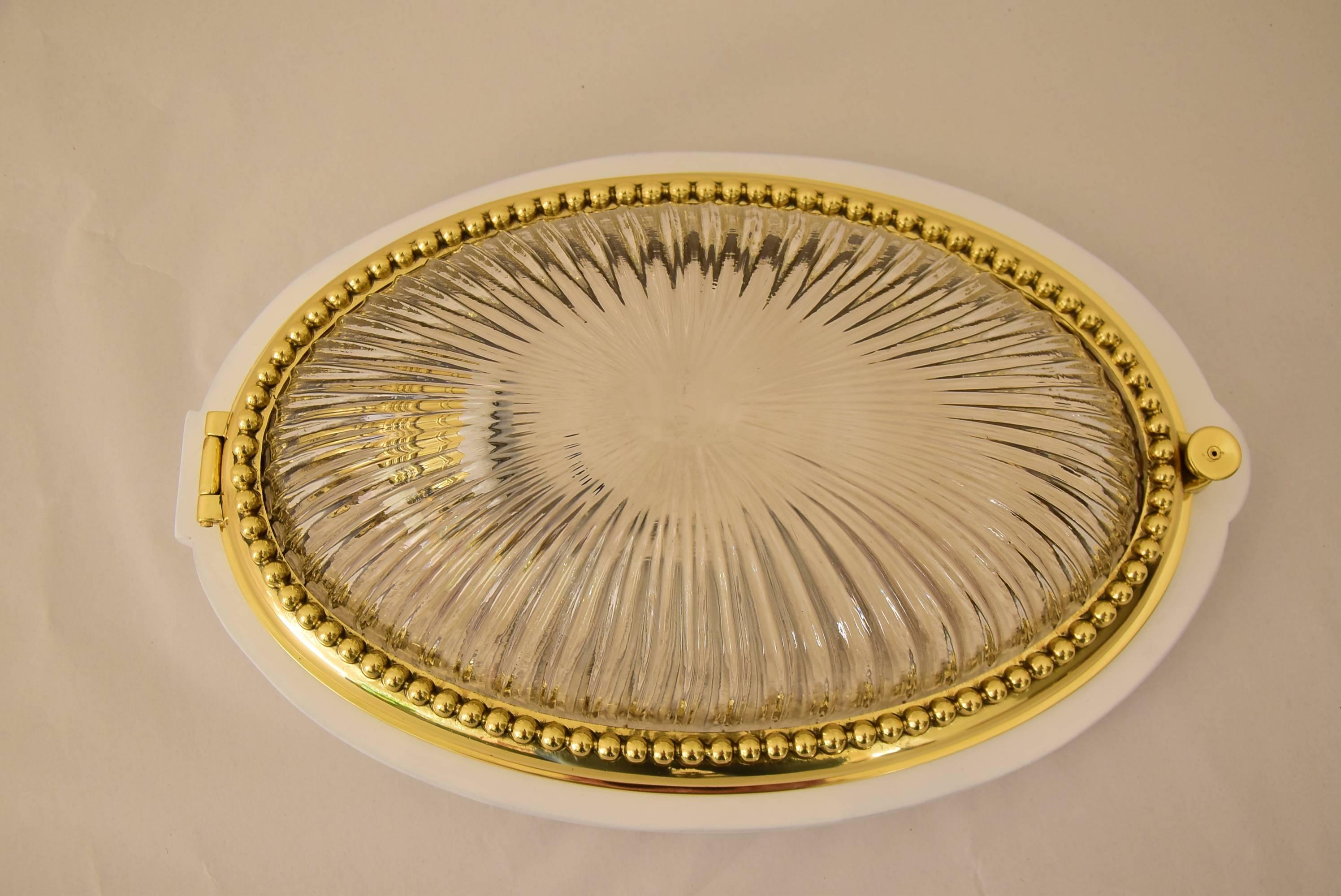 Jugendstil oval ceiling lamp with hinge and cut glass.
Wood plate is white painted.
Brass is polished and stove enamelled.