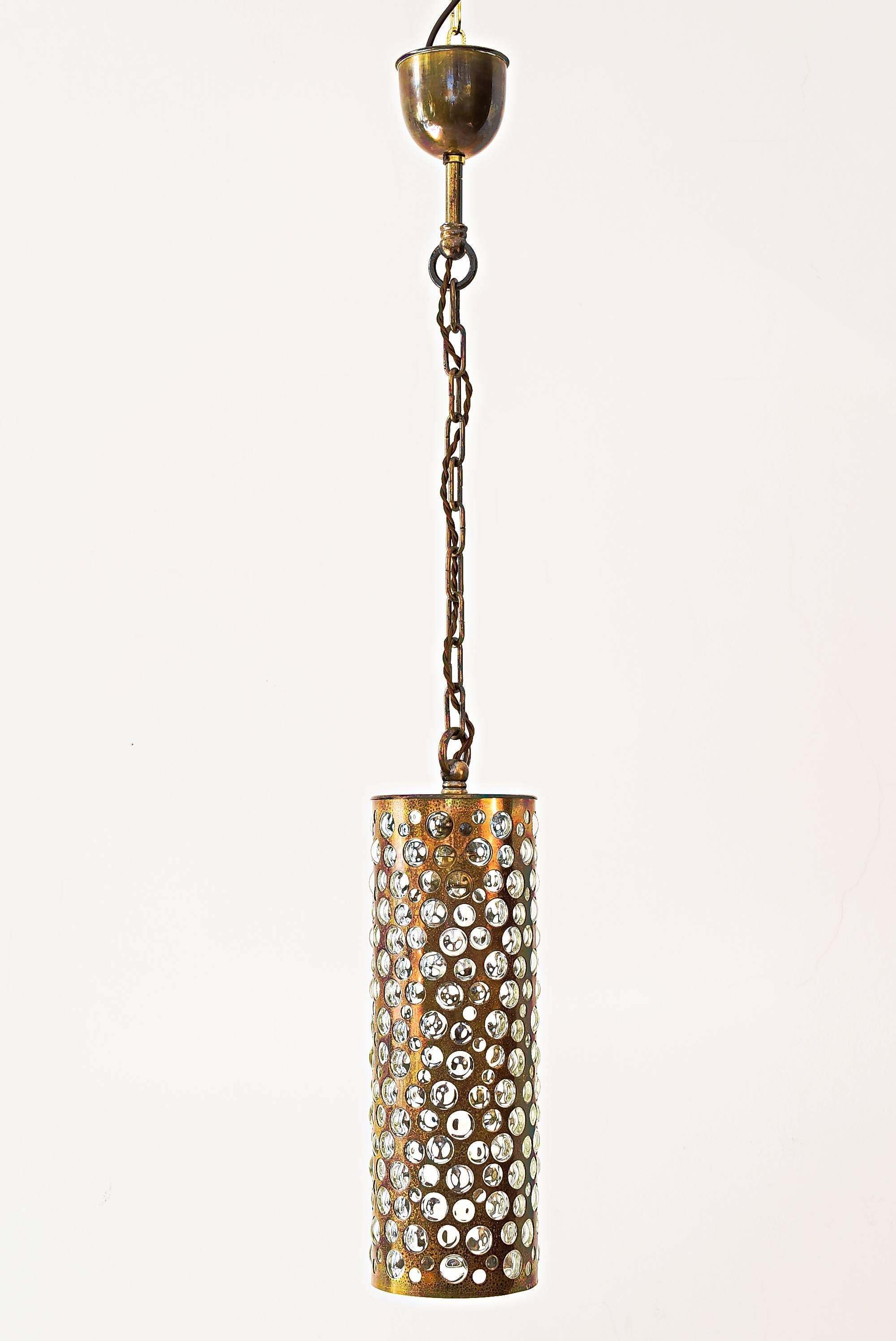 This fixture features handblown bubble and textured glass piercing through a patinized (bronze colored) metal sheet. The hardware is made from brass.
Measures: Complete high is 90 cm.
Glass high is 36 cm.
Glass diameter is 12 cm.
