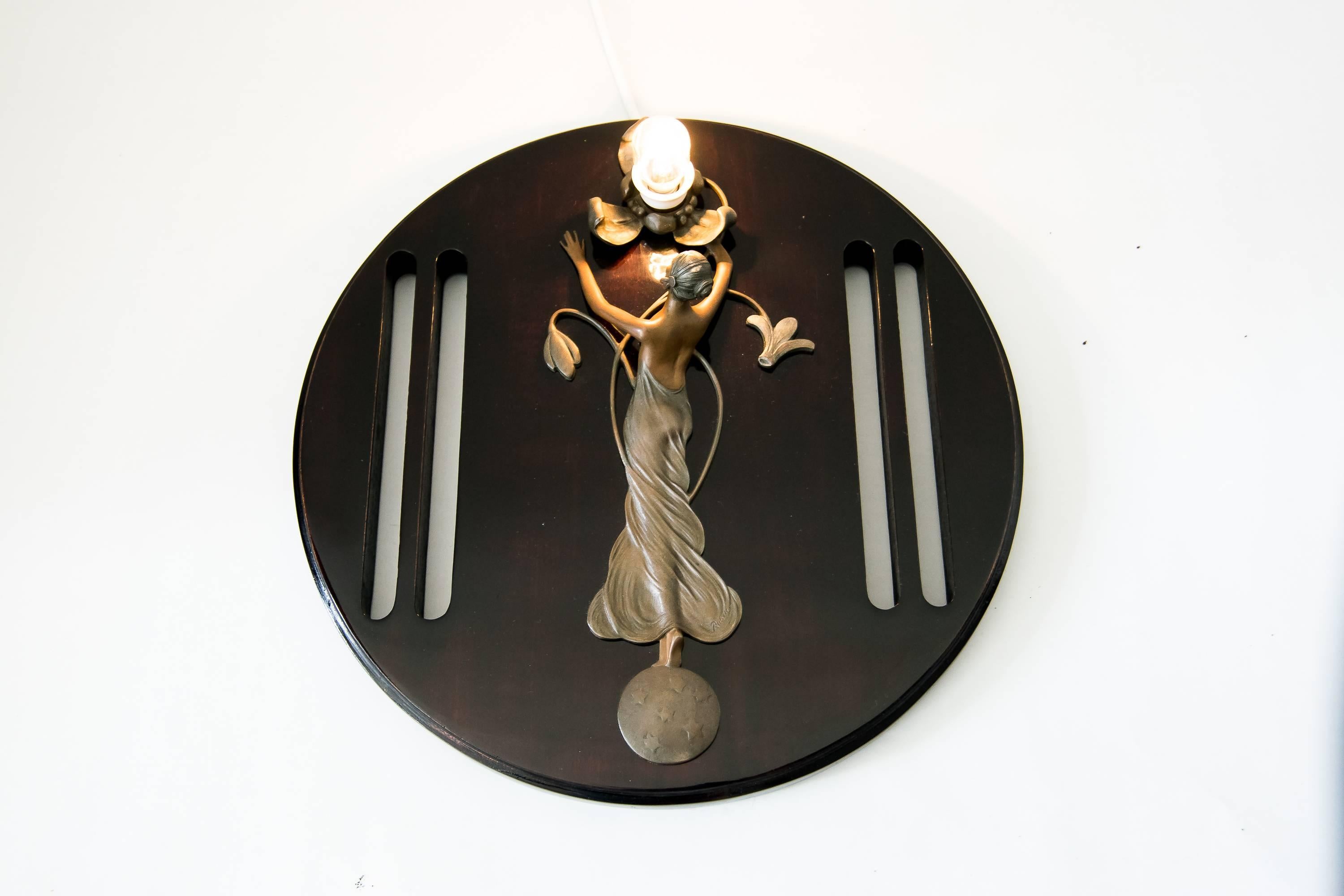 Auguste Rubin figural bronze wall lamp on wood
Wood polished 
Signed by the artist August Rubin.