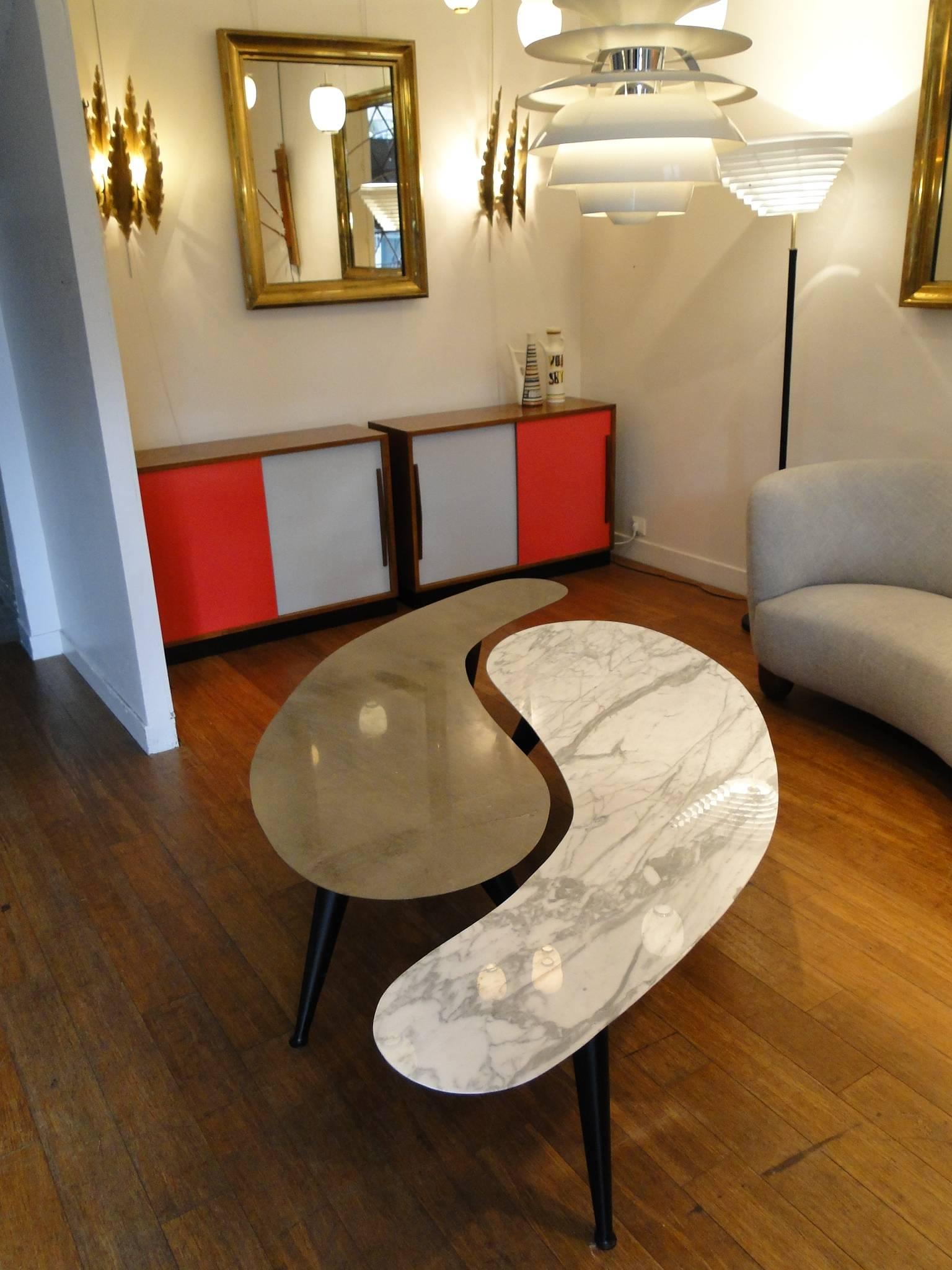 Beautiful pair of cocktail tables with a finely polished marble top, three black lacquered metal legs.