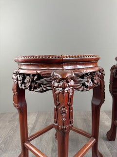 Juego de dos mesitas chinas con pedestal, de madera tallada y mármol, del siglo XX