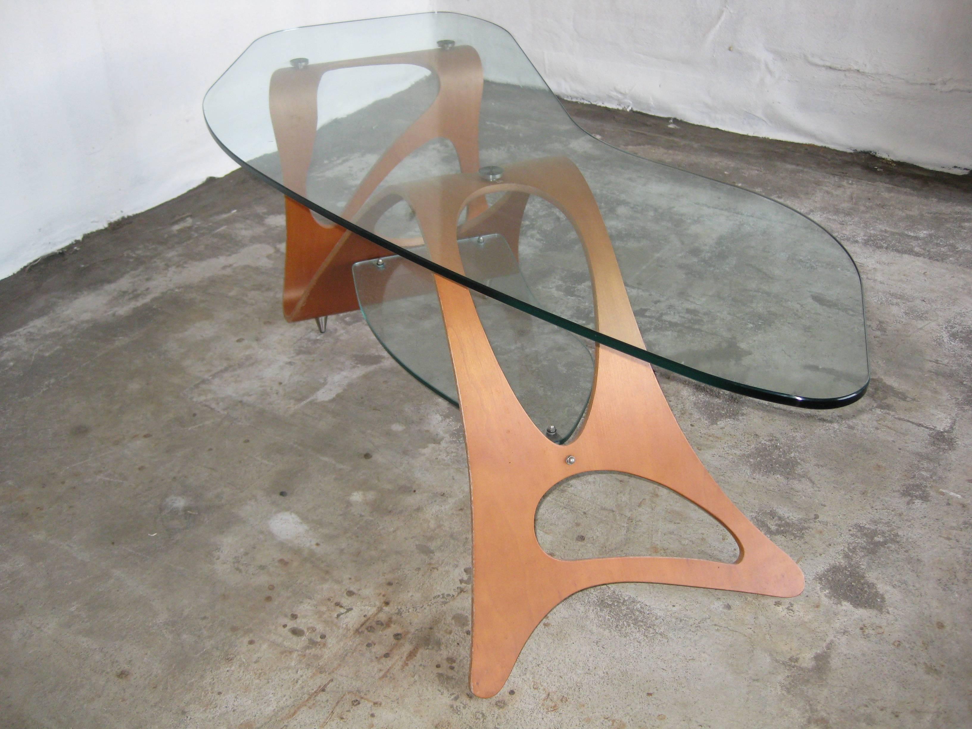 Arabesco coffee table design by Carlo Mollino 1949 for the living room of Casa Orenga in Turin.
Plywooly wood legs with glass top.
Original Zanotta production. 
 Manufacture logo in the wooden base.
