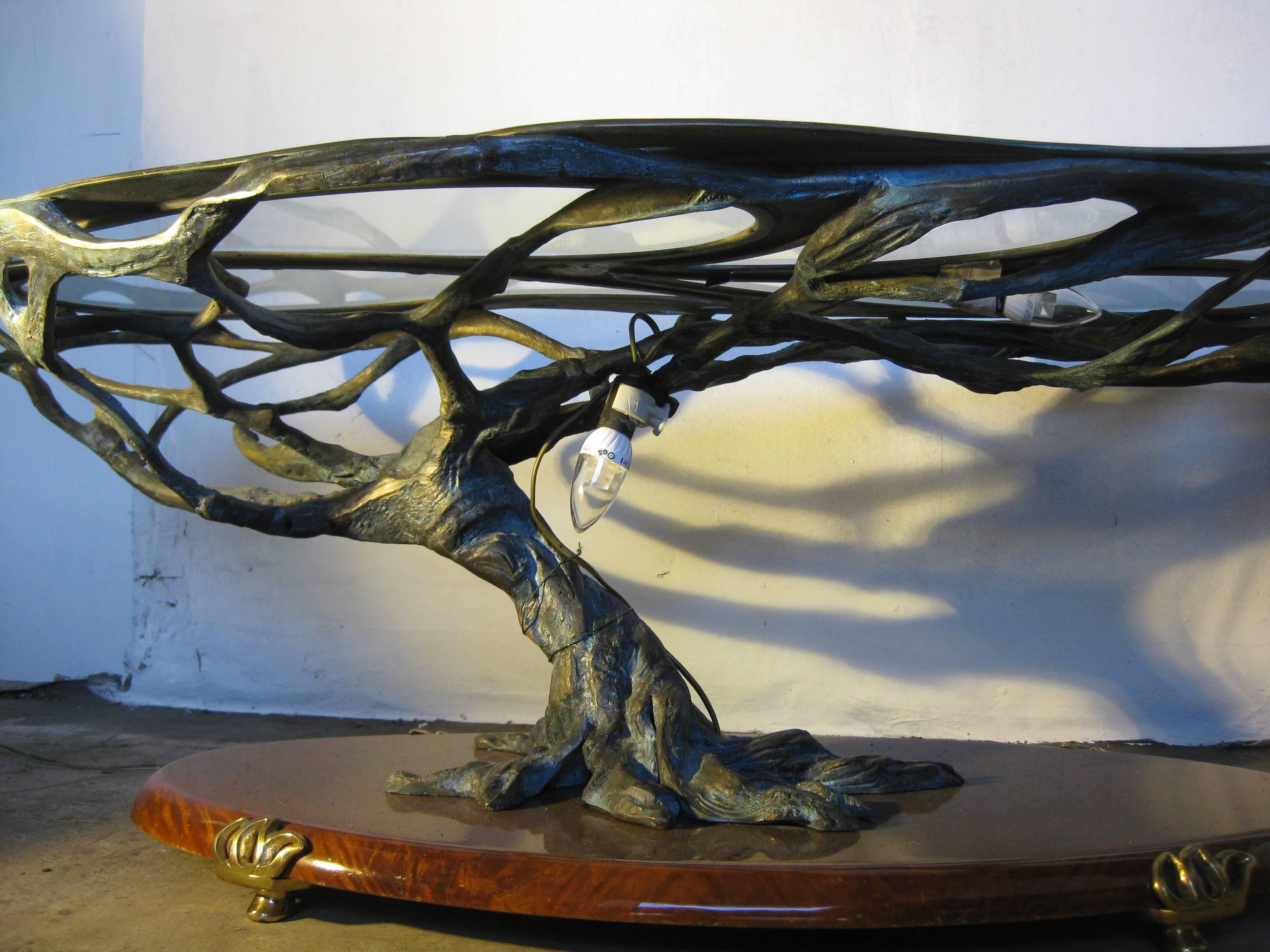 Showstopper salon coffee table from Italian origine.
Bronze sculptural very heavy base leaning on wallnut with brass detailed foot.It is inlayed with five teardrop-shaped removeable glass plates.
The combination of the clearcut abstract leaflike top
