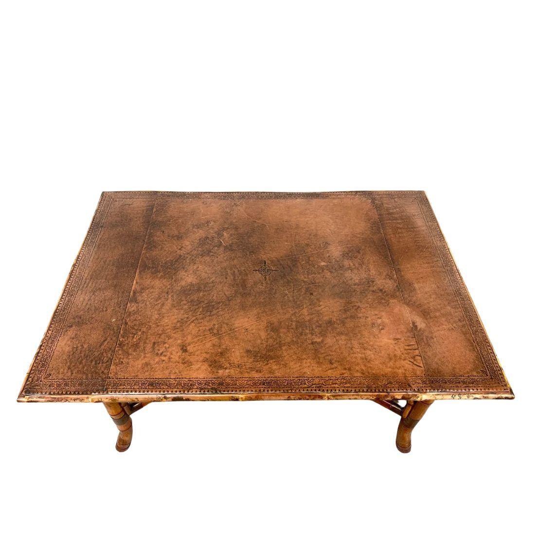 This distinctive rectangular dining table combines rich texture with organic elegance, featuring a tooled leather tabletop that adds depth, pattern, and a refined tactile quality. The surface showcases intricate detailing, lending an artisanal touch