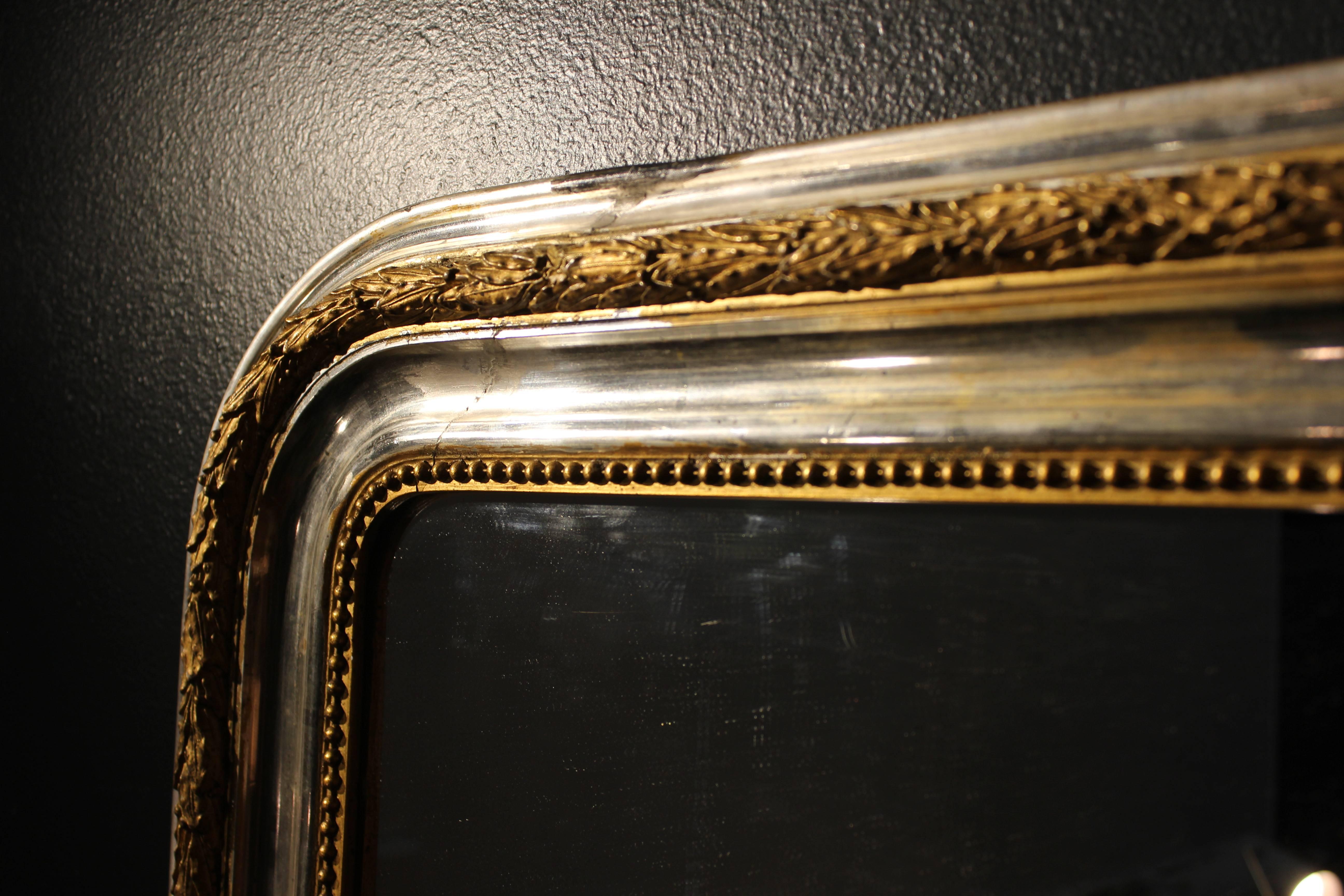 Large silver and gold leaf mirror with carved frame.