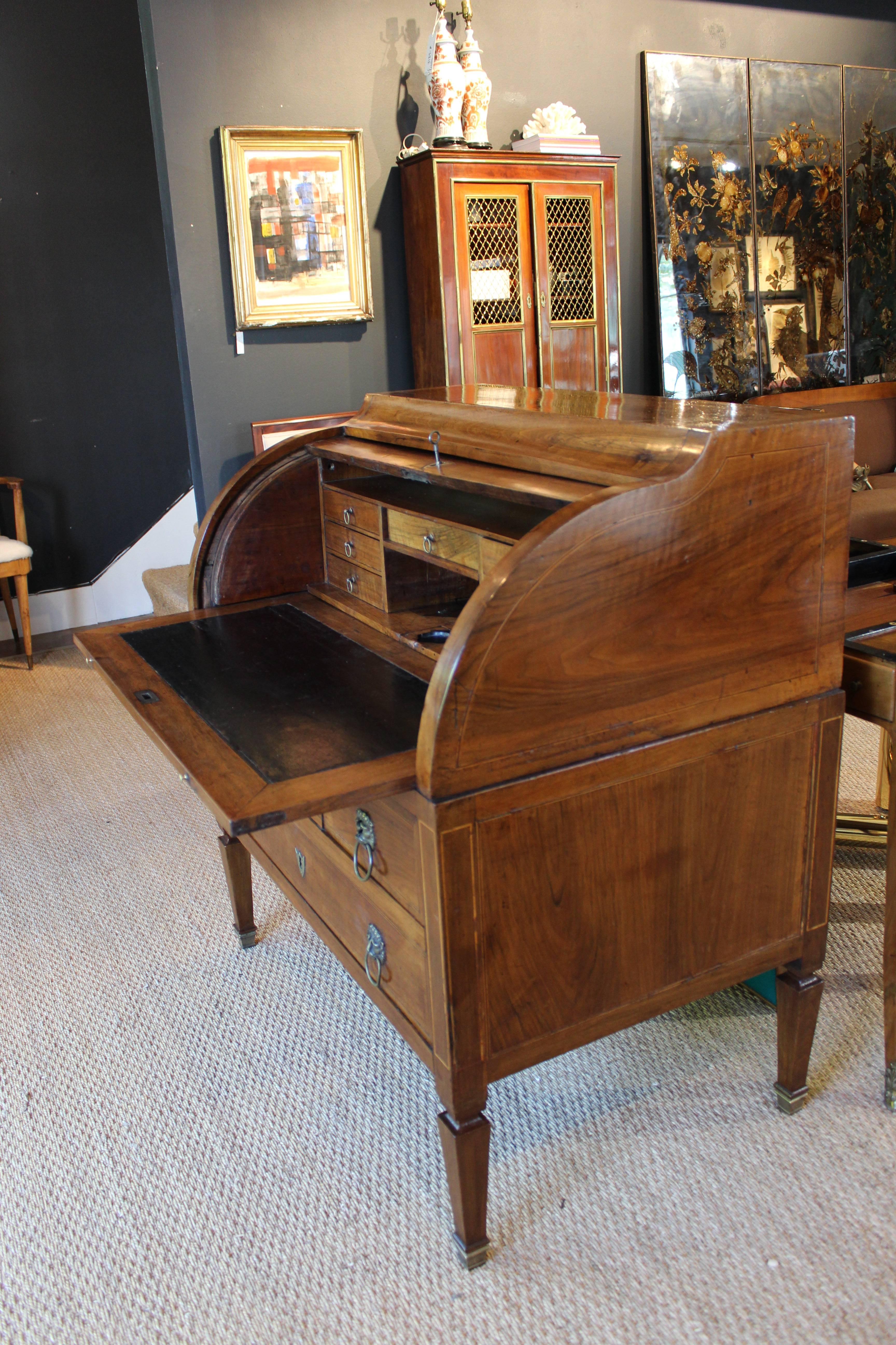 Stunning two-piece hooded bureau secretary desk with slide-out black leather writing surface and original Lionhead drawer pulls. Center console includes inkwell holder and secret compartment that drops to the faux middle drawer on bottom. Bronze
