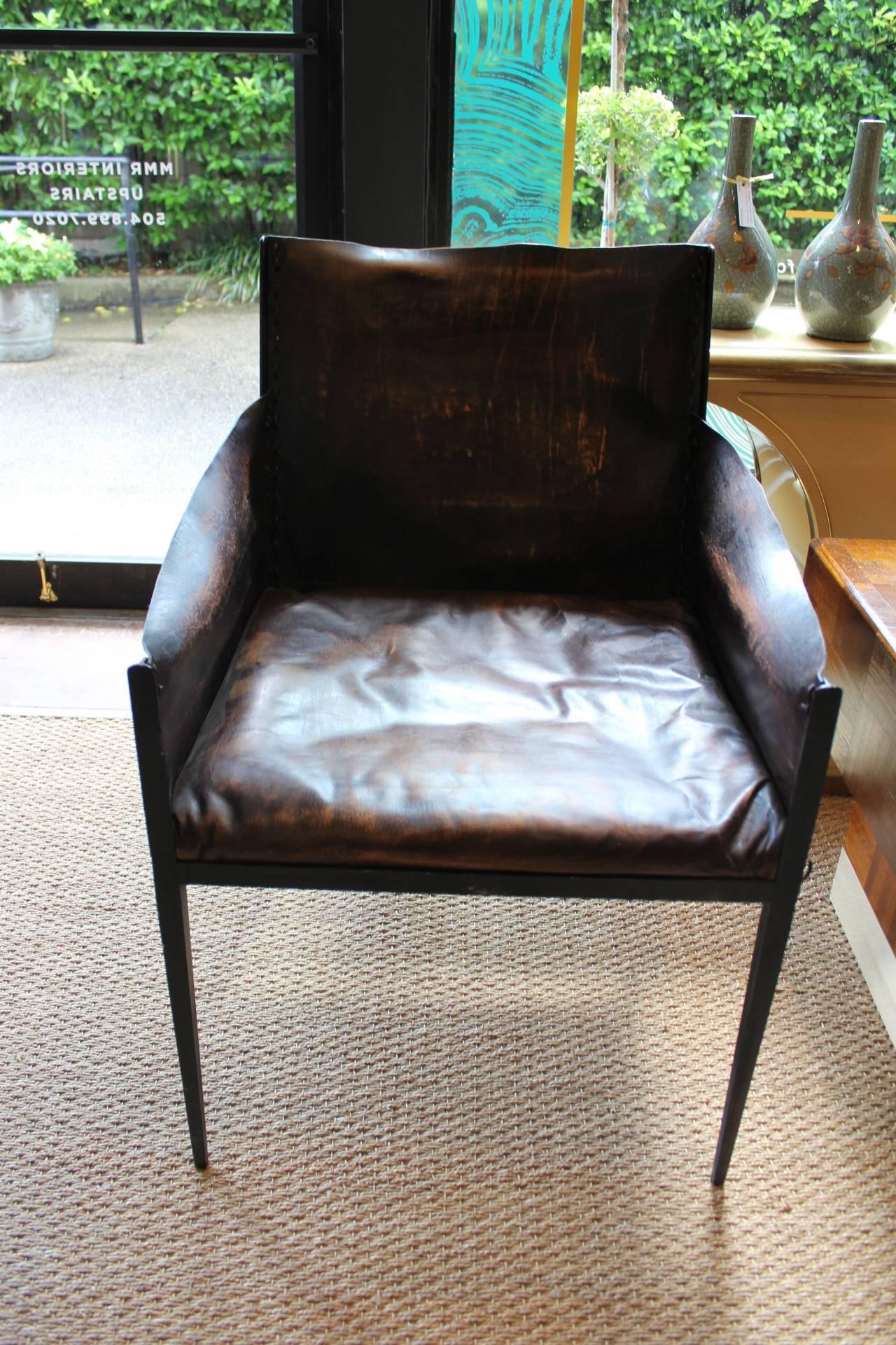 Gorgeous pair of old, worn leather chairs with padded seat and leather back, arms. Sits on iron support with leather lacing details. Design attributed to Jean-Michel Frank (1895-1941), unmarked.