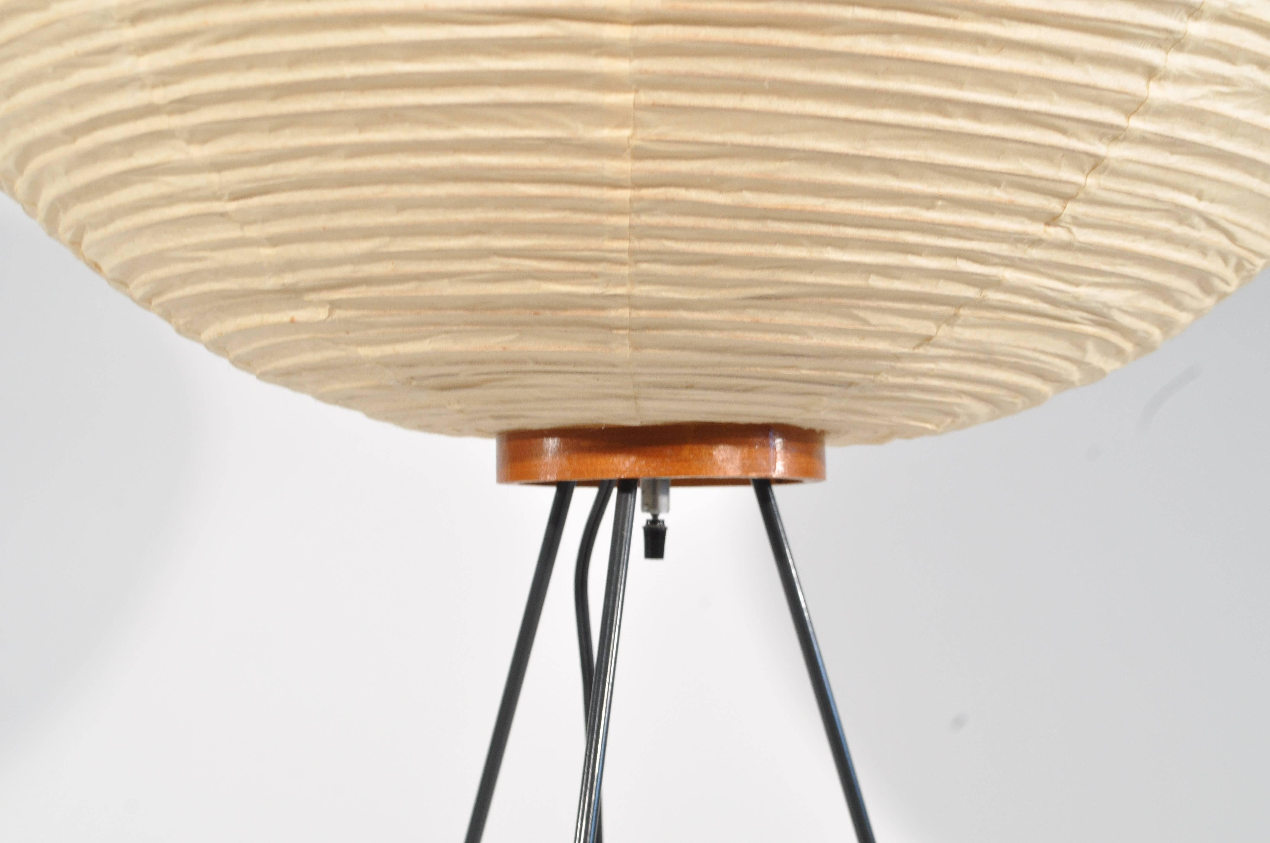 An early piece in the organic style that Noguchi was best known for. This lamp is from the 1960s, featuring a suspended paper shade on tripod base. Model 3A, with the Noguchi and Akari stamp.

Dimensions: Height 39