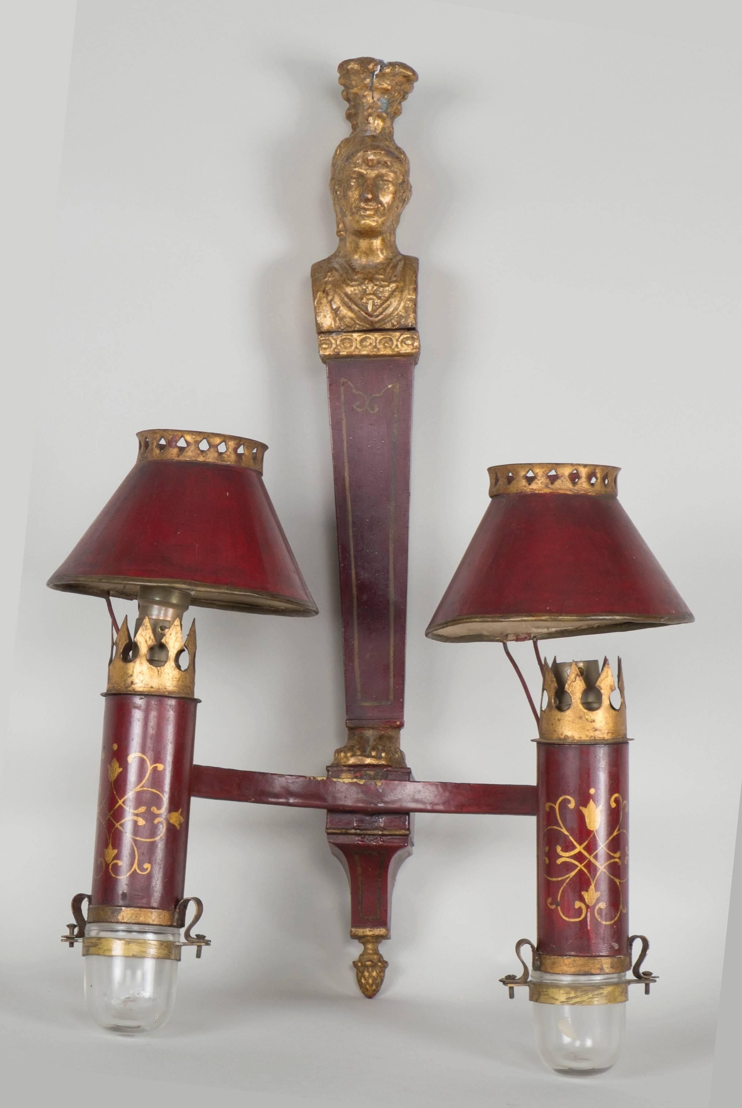 Set of three red sheet metals sconces depicting removable heads of caryatids.

Work from the beginning of the 19th century.

Dimensions:

55 cm H x 35 cm L.
