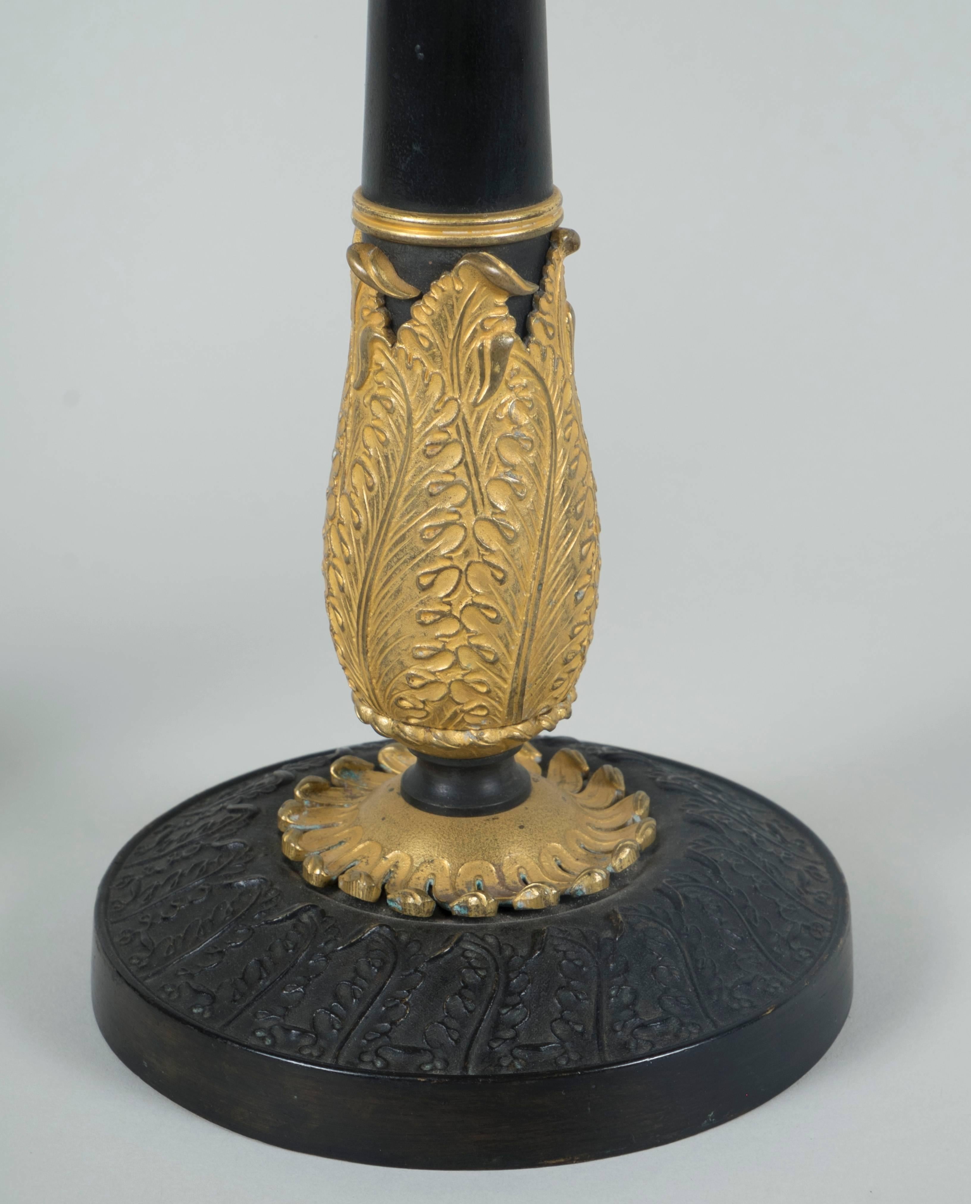 Pair of gilt and patinated bronze candlesticks.

Work from the 19th century, circa 1815.

Dimensions:
30 cm H x 12.5 cm D.
