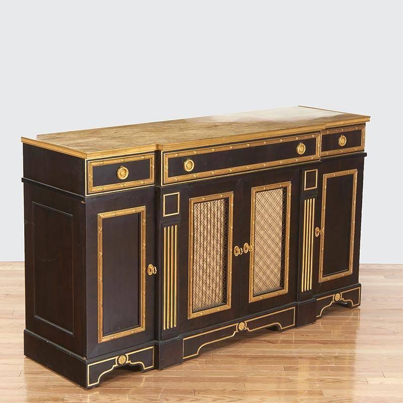 The breakfront marble top within a gilt bronze banded edge over three frieze drawers, set above four cabinet doors opening to shelves; mounted with finely cast neoclassical ormolu mounts.