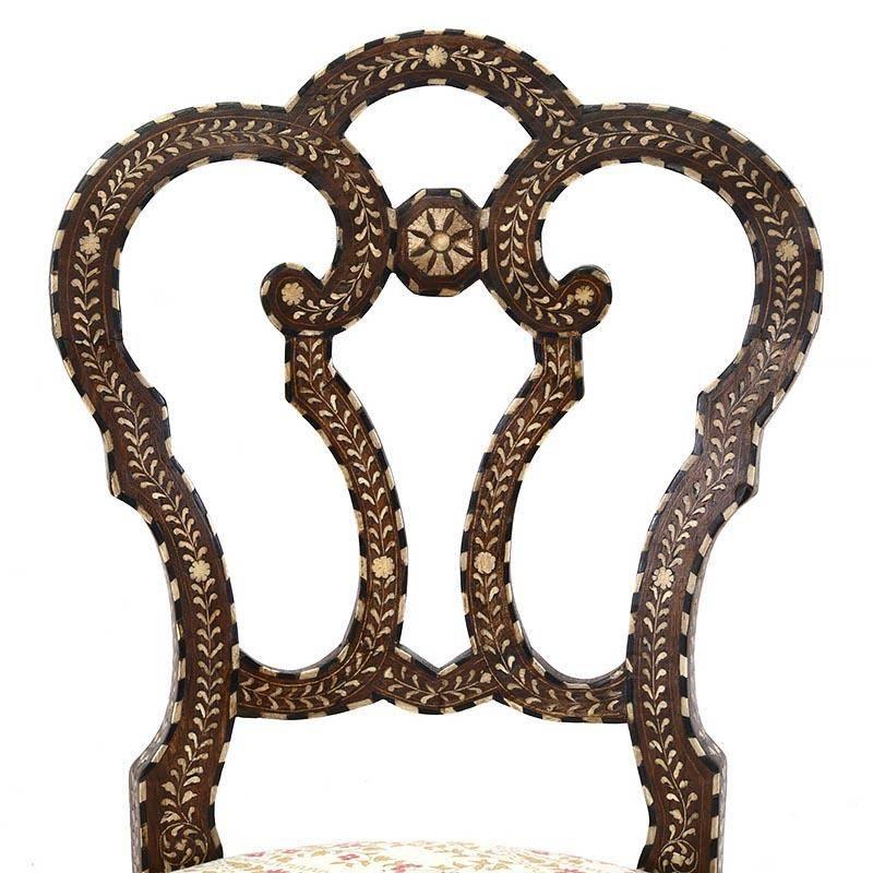 Inlaid throughout with scrolling vinework and flowerheads; each with open interlaced backsplat and upholstered seat raised on front cabriole legs.