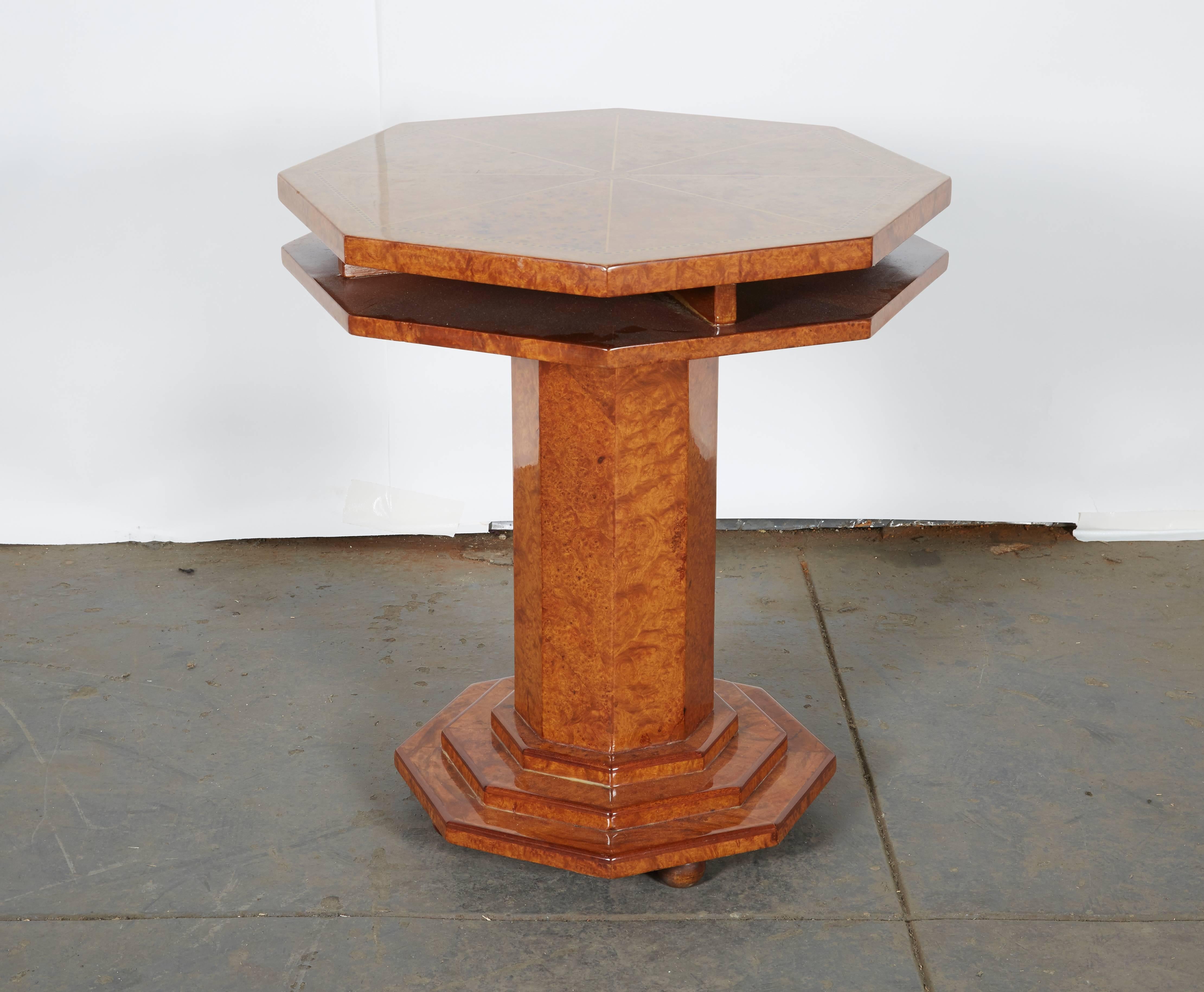 The two tier top with radiating veneers and checkerboard banding raised on a chamfered pedestal support and tiered plinth base; on ball form feet.

Provenance: Karl Kemp Antiques, New York, NY.