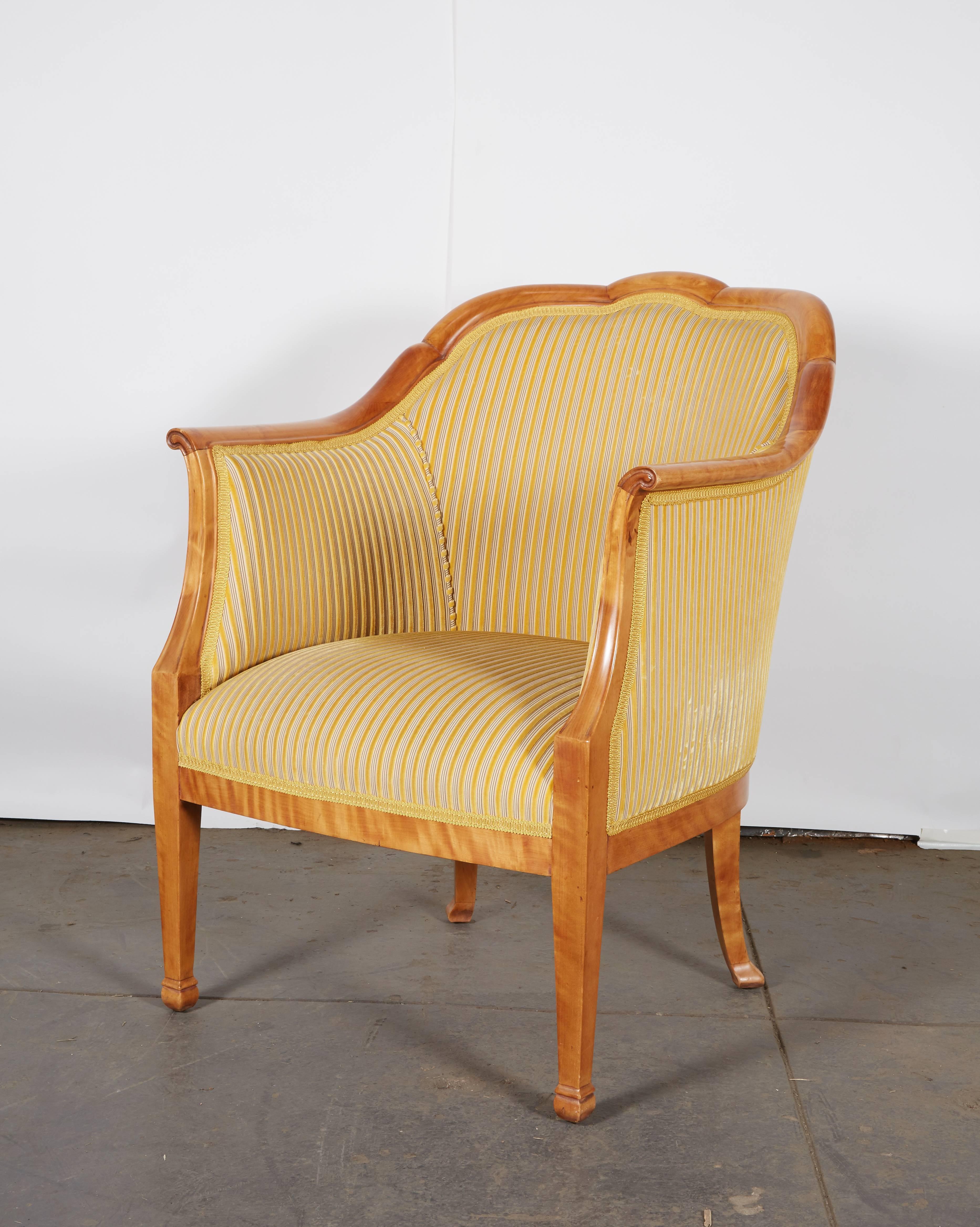 Streamlined neoclassical lines distinguish this pair of elegant armchairs. Raised on square tapering legs ending in block feet. Upholstered in Nobilis striped velvet in yellow and gold.