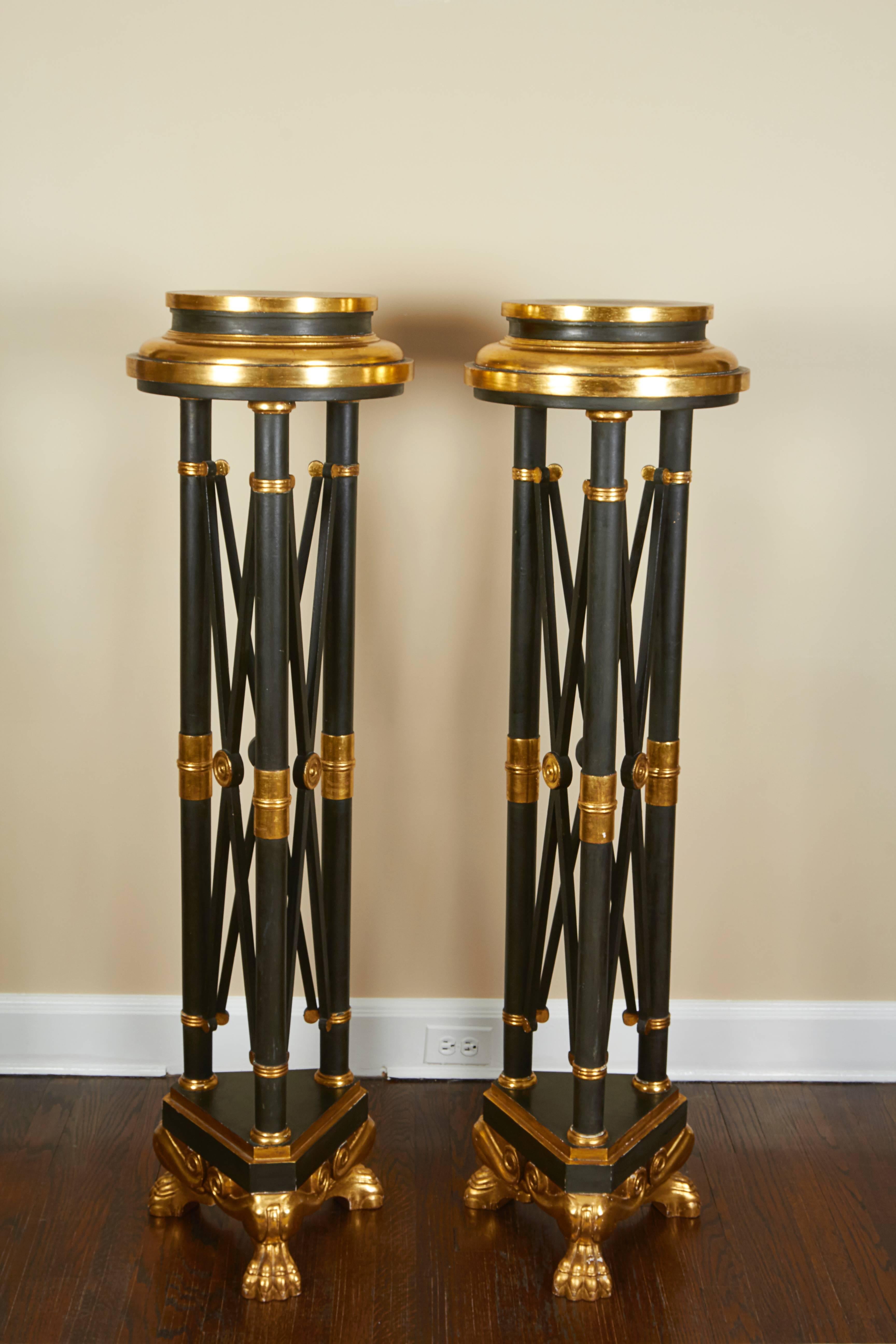 Dramatic neoclassical black pedestals picked out in gold, raised on bold paw feet.