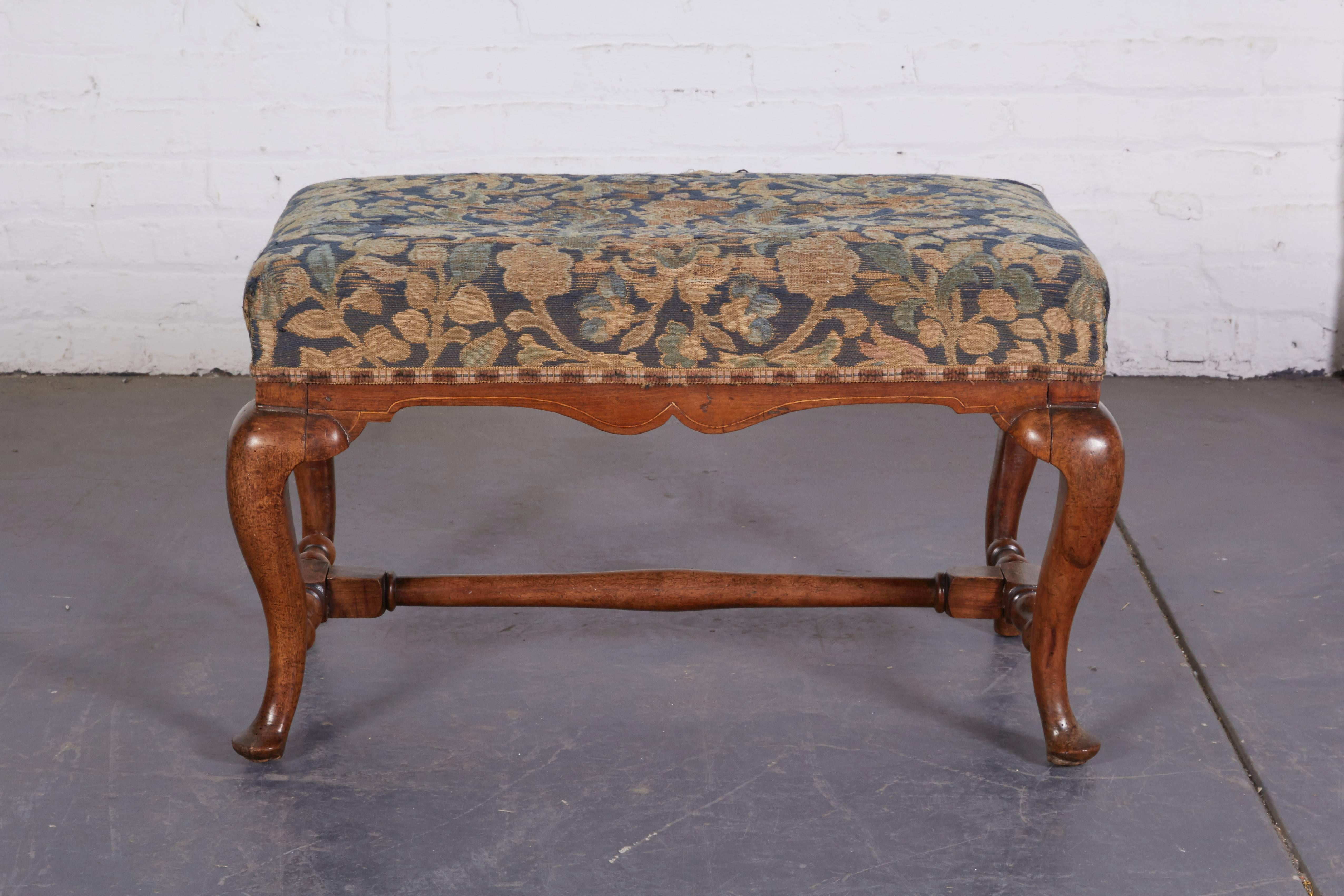 The rectangular seat upholstered in antique verdure textile, over the shaped seat rail; raised on cabriole legs joined by a turned H-form stretcher and terminating in pad feet. Upholstery is fragile - small area of wear seen in photo can be repaired.
