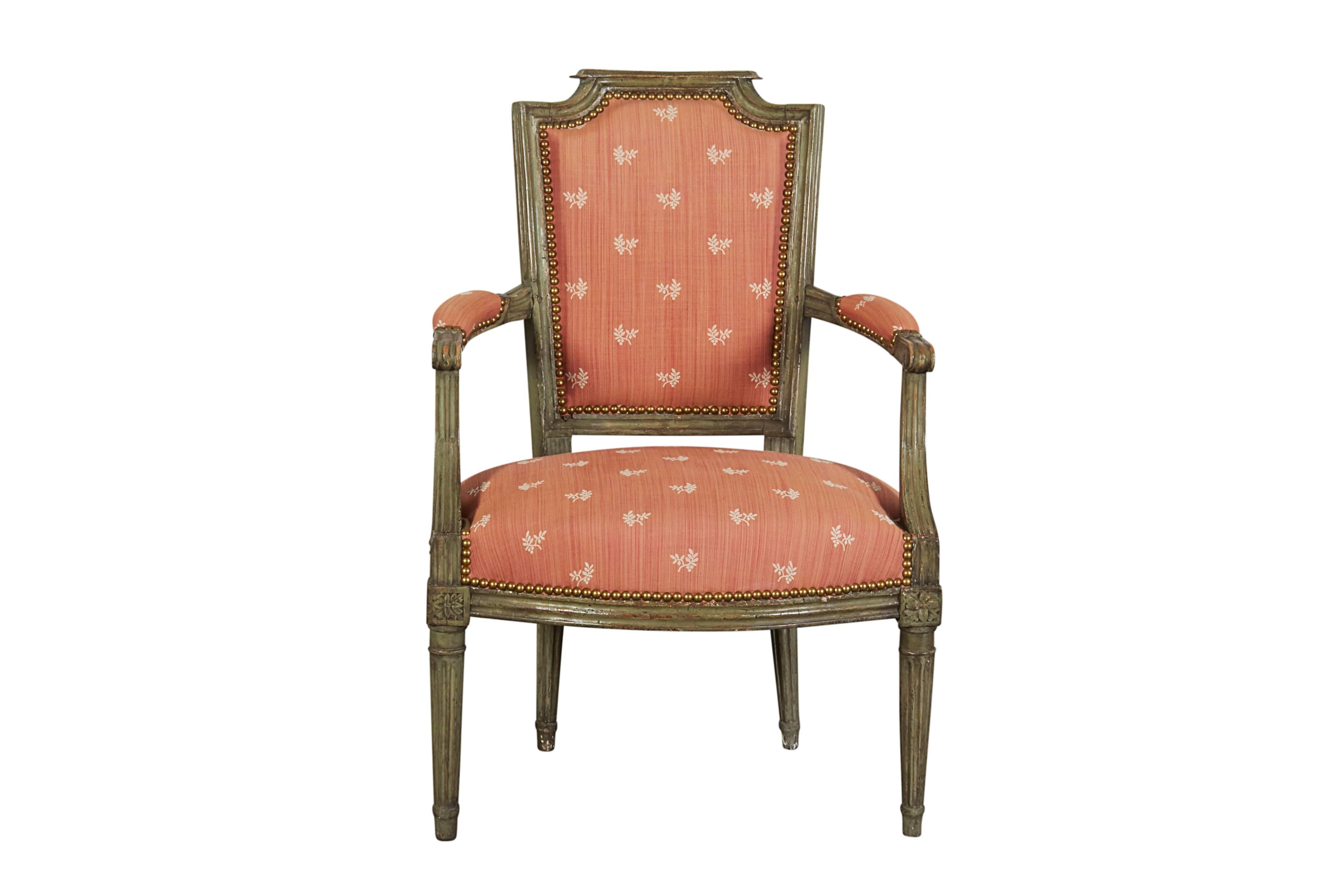 With upholstered back and seat and padded armrests raised on stop-fluted tapering legs headed by floral rosettes. Nicely scaled to use as a desk chair.