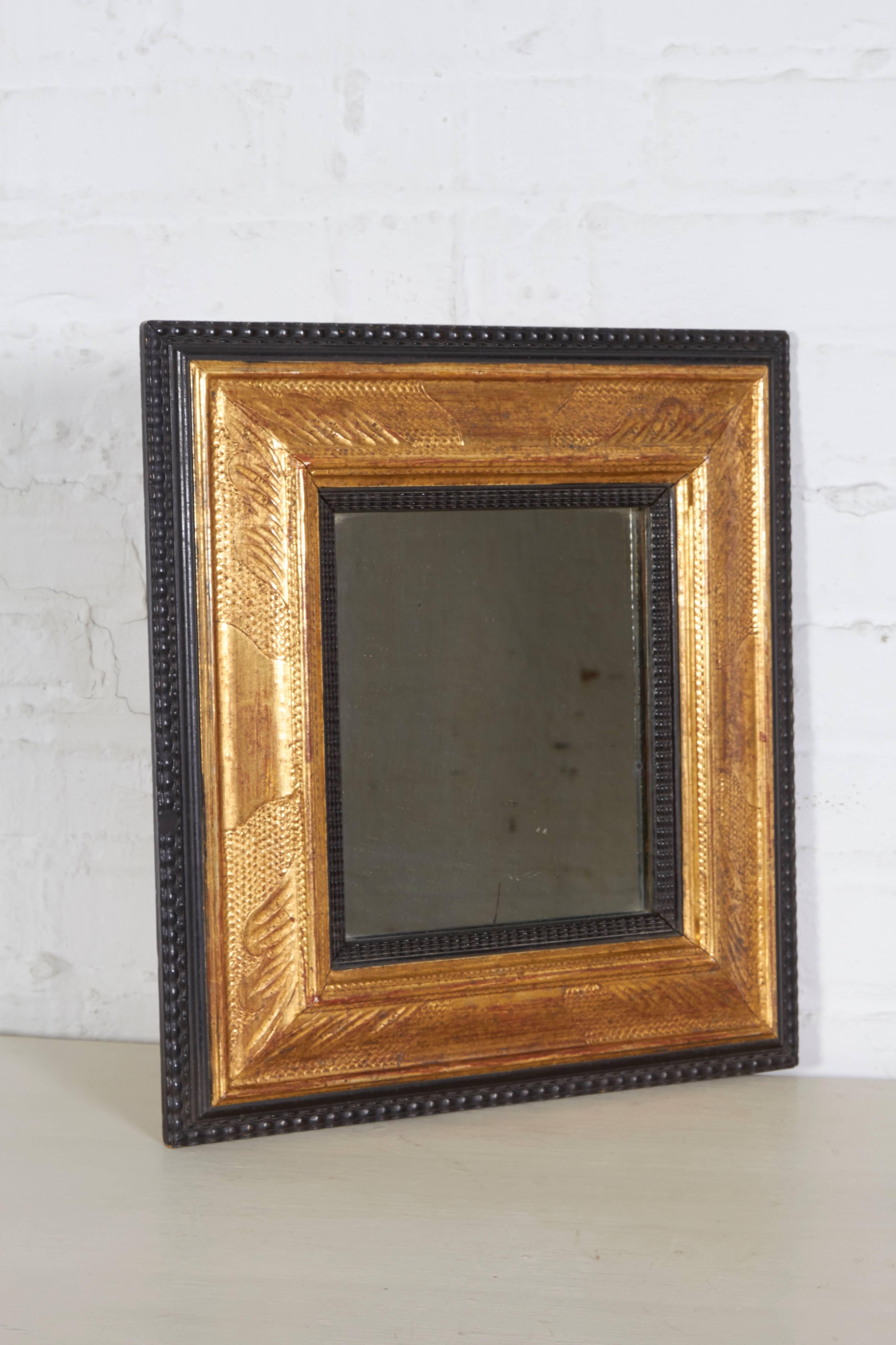 The rectangular mirror plate set within a conforming hand-carved frame with ripple cut edge and giltwood surround. Bearing Heydenryk label on reverse.